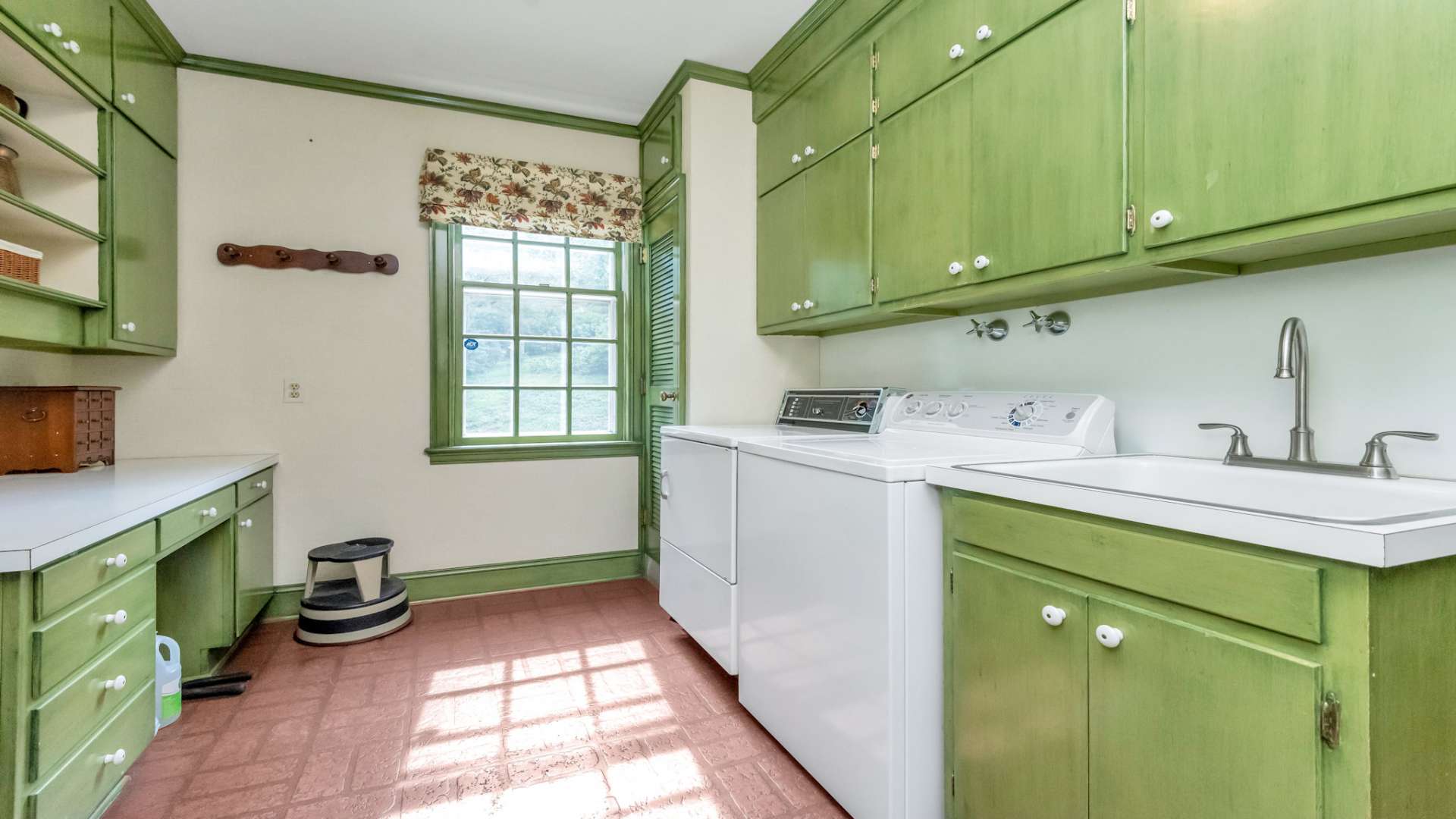 Accessed from the kitchen or the outdoors, the laundry room is spacious and features lots of built-ins for storage, a laundry sink, a sewing desk, and a "dry" drain for those items that need to drip dry. One of the three half baths is conveniently located in this area.