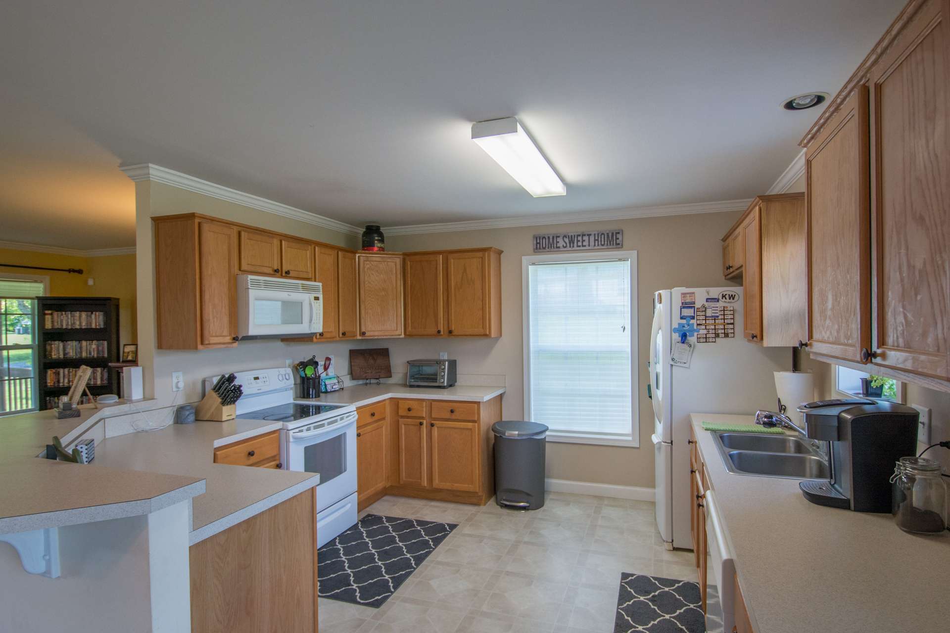 The kitchen offers plenty of work and storage space and includes a bar with seating space.