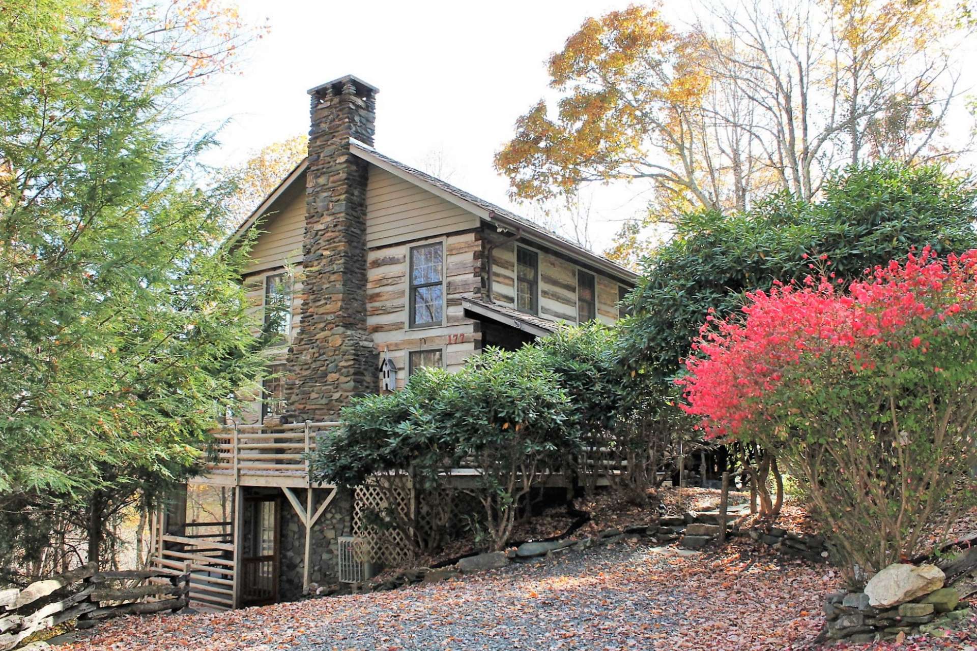 Beautiful shrubs such as rhododendrons and burning bushes provide a scenic entrance. The level driveway and native stone walkway leads you to the covered front porch.