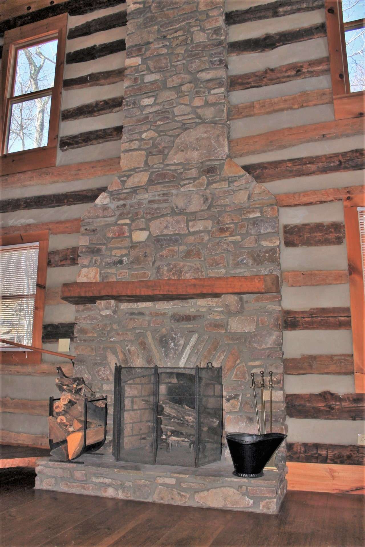 The great room's cathedral ceiling is highlighted by the soaring wood-burning stone fireplace.