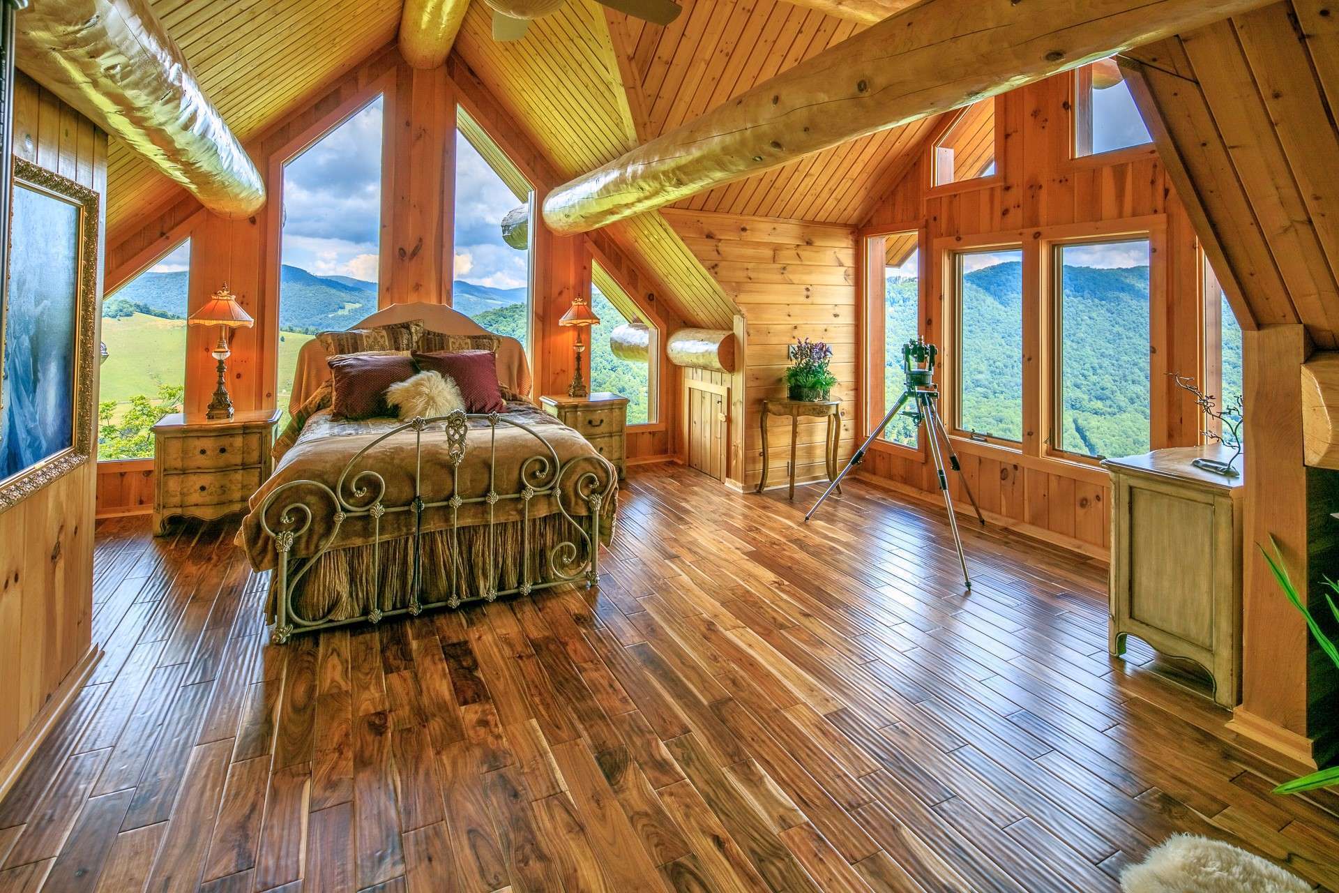 This is the upper level guest bedroom with abundant windows, the third stone fireplace, and a private bath.