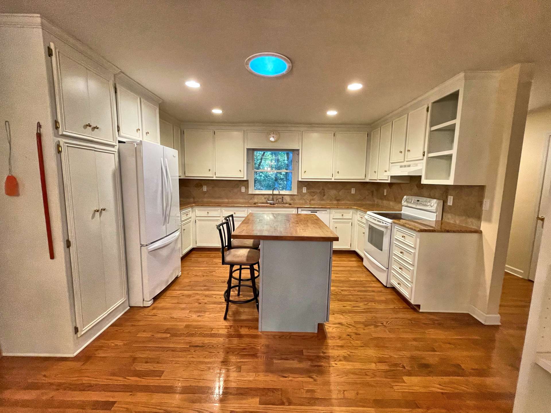 Nicely appointed kitchen with white cabinets and kitchen island.