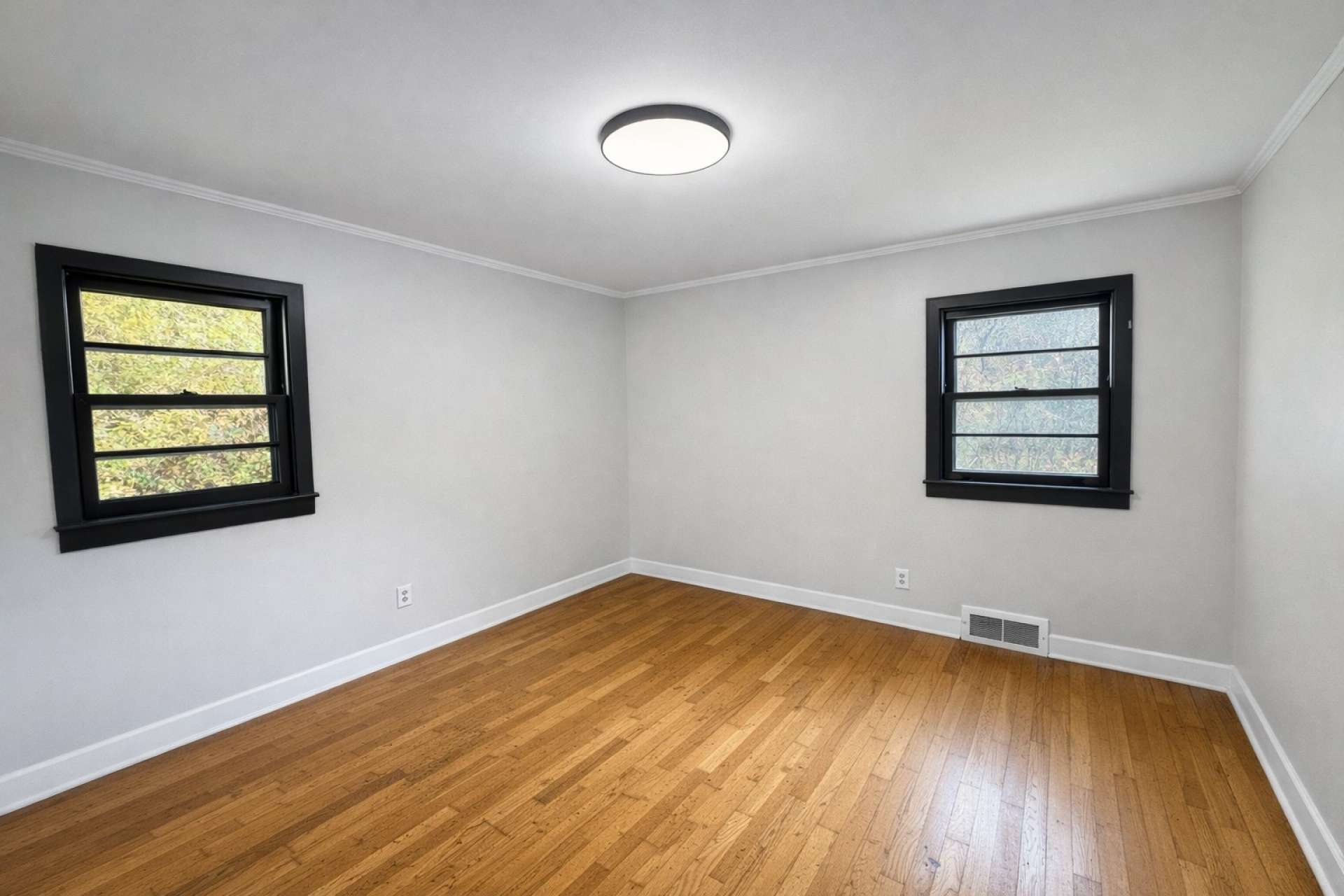 Another virtual-generated photo showing how a new coat of paint, updated lighting, and buffed floor can freshen up this bedroom.