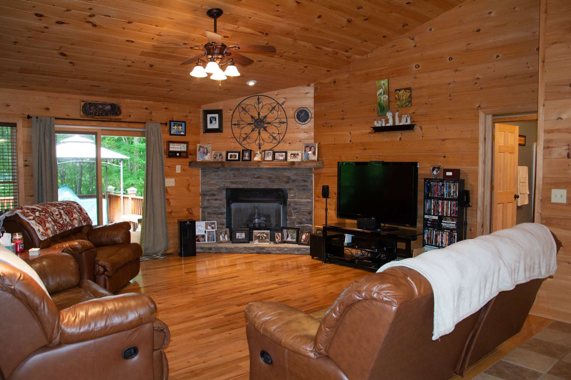 The open great room features a vaulted wood ceiling, gleaming wood floors, and a stone fireplace with gas logs to warm up those chilly winter evenings.