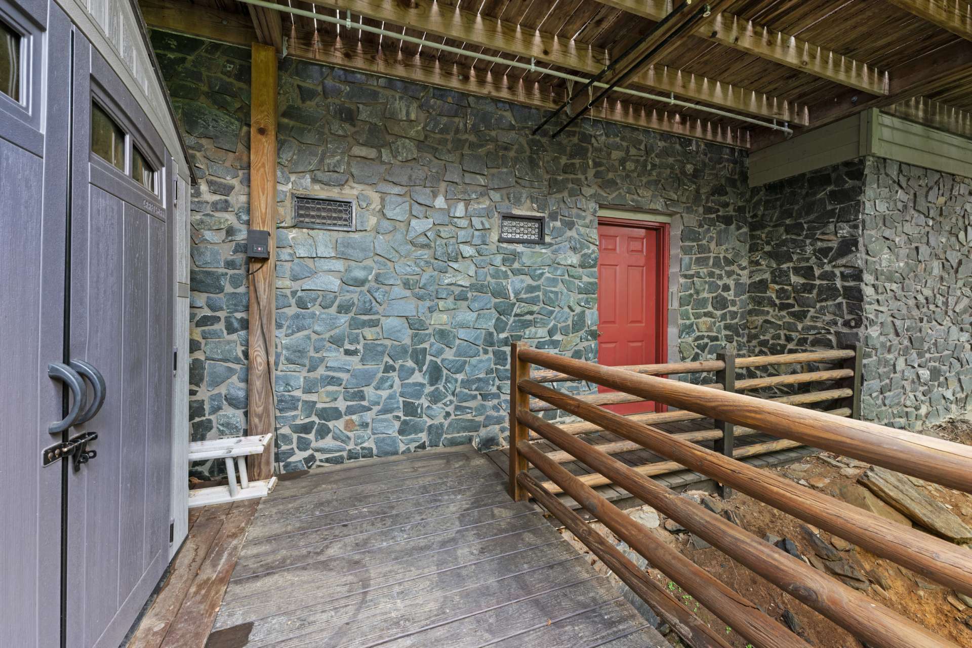 Tucked discreetly below the lower deck, a storage shed and crawl space provide practical solutions for organizing outdoor essentials.