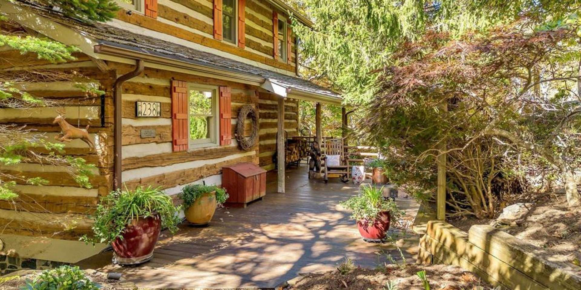 A flagstone path with landscape lighting leads to the charming entry patio, surrounded by layers of curated plantings and native trees for year-round beauty and privacy.