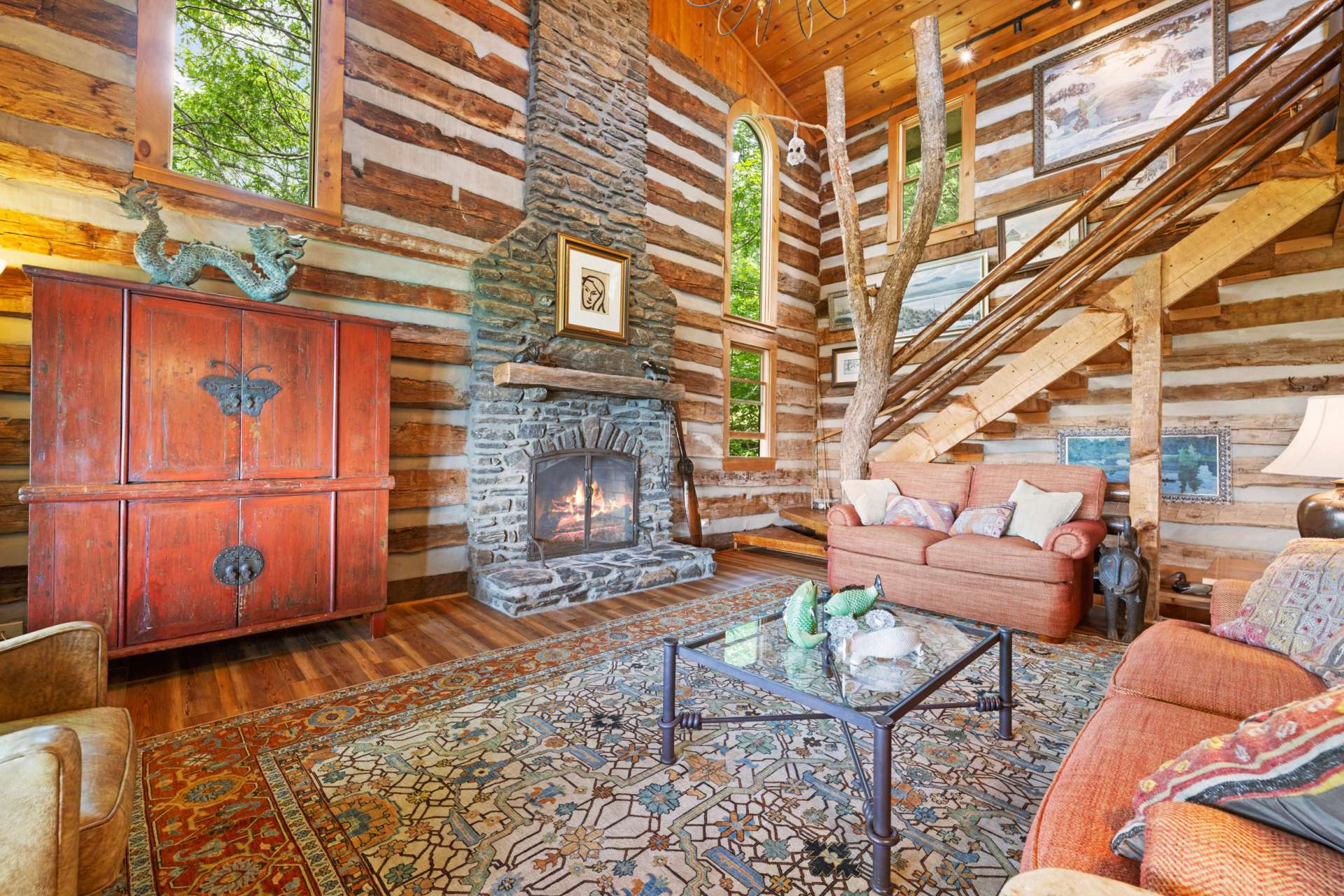 Soaring ceilings and a dramatic floor-to-ceiling stone fireplace create a grand yet intimate space designed for gathering and relaxing.