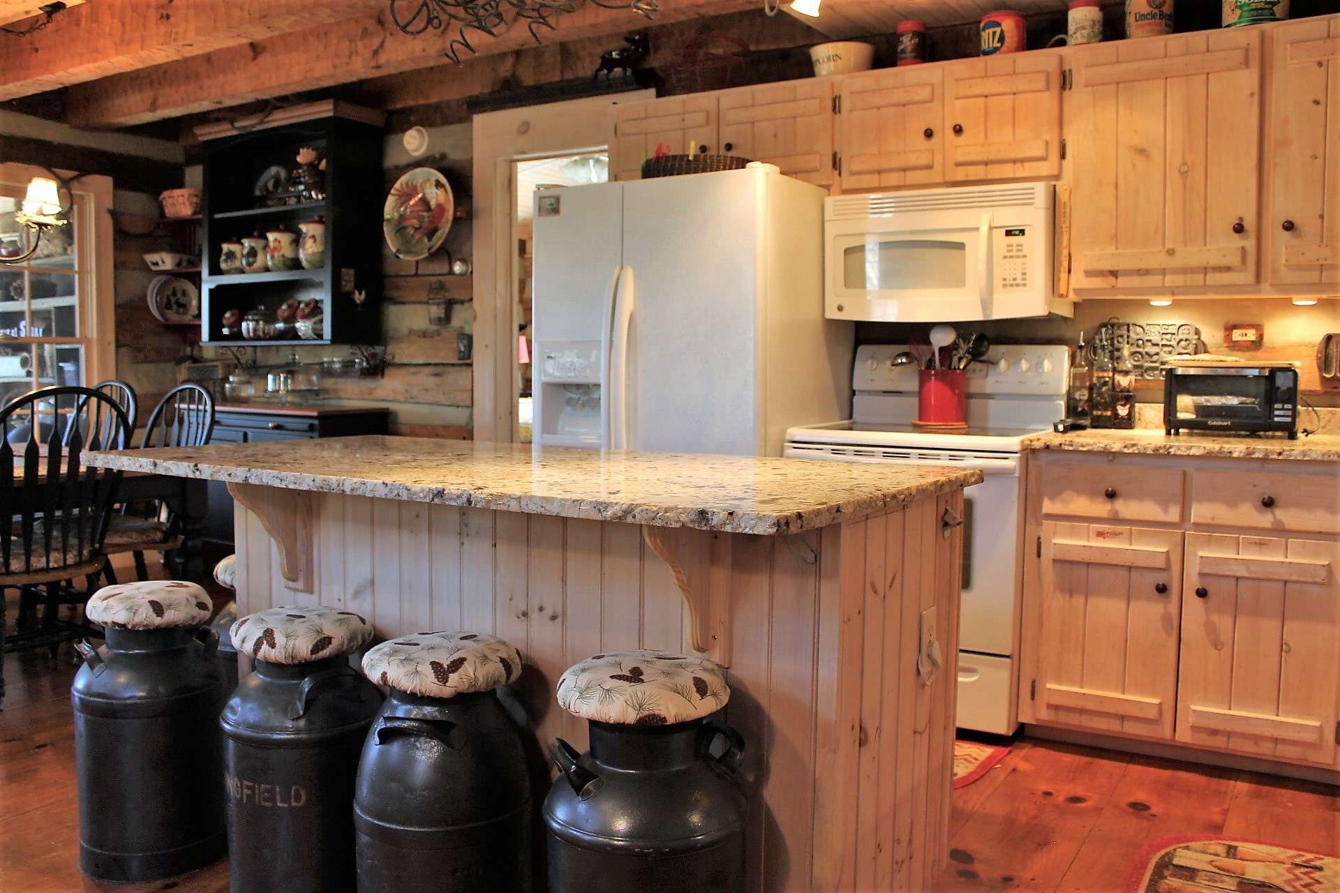 Granite countertops and island are finished with chiseled rough edge for a custom look and offer plenty of bar seating for casual meals.