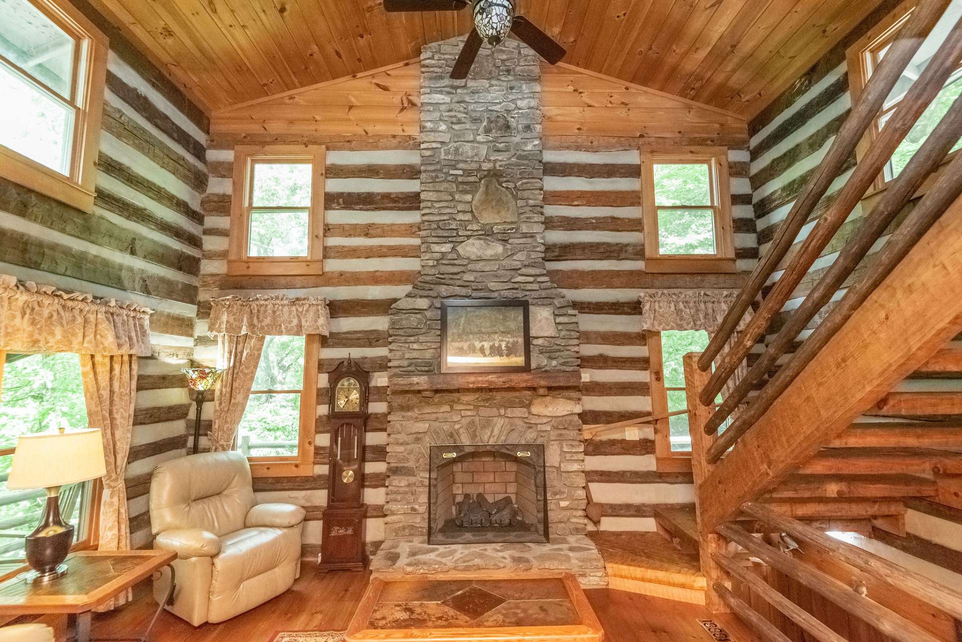 Two story stone fireplace with gas logs soars to the vaulted ceiling.