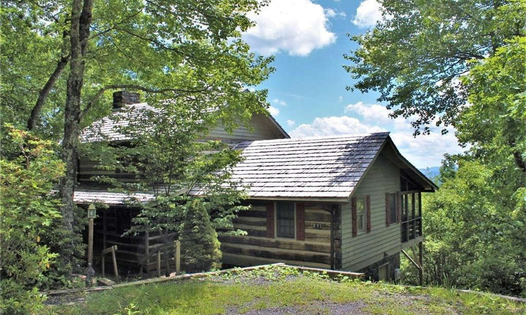 WOODED RETREAT!  High in the mountains of North Carolina, there is an antique log home community that preserves the rustic mountain cabin living experience while enjoying all of today's modern conveniences. This magical place is called STONEBRIDGE.  Tucked away in a wooded setting, you will find this charming 2-bedroom, 2-bath log cabin boasting tremendous long range layered views.