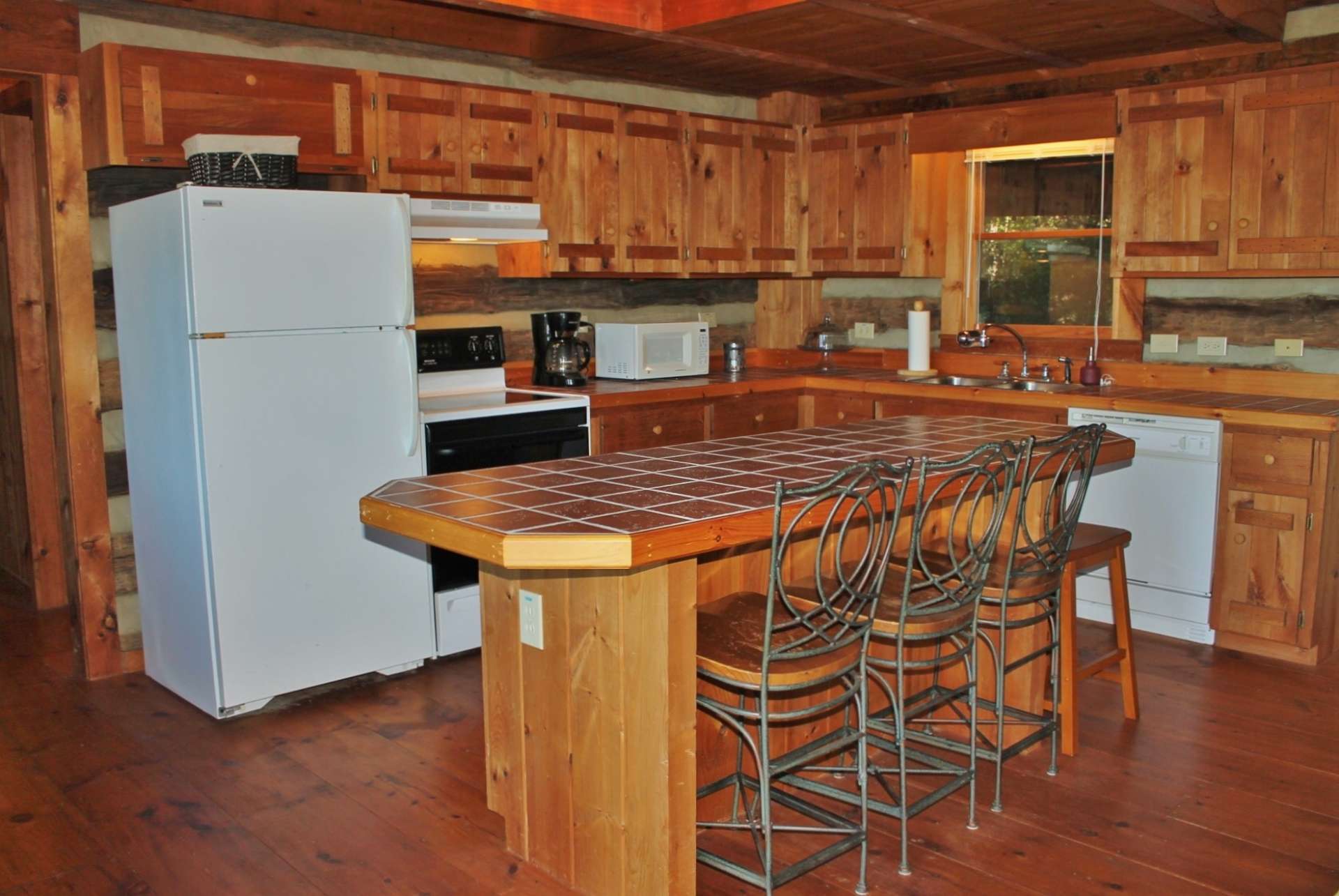 The step saving and efficient kitchen offers ample work and storage space that includes a center island with bar seating.