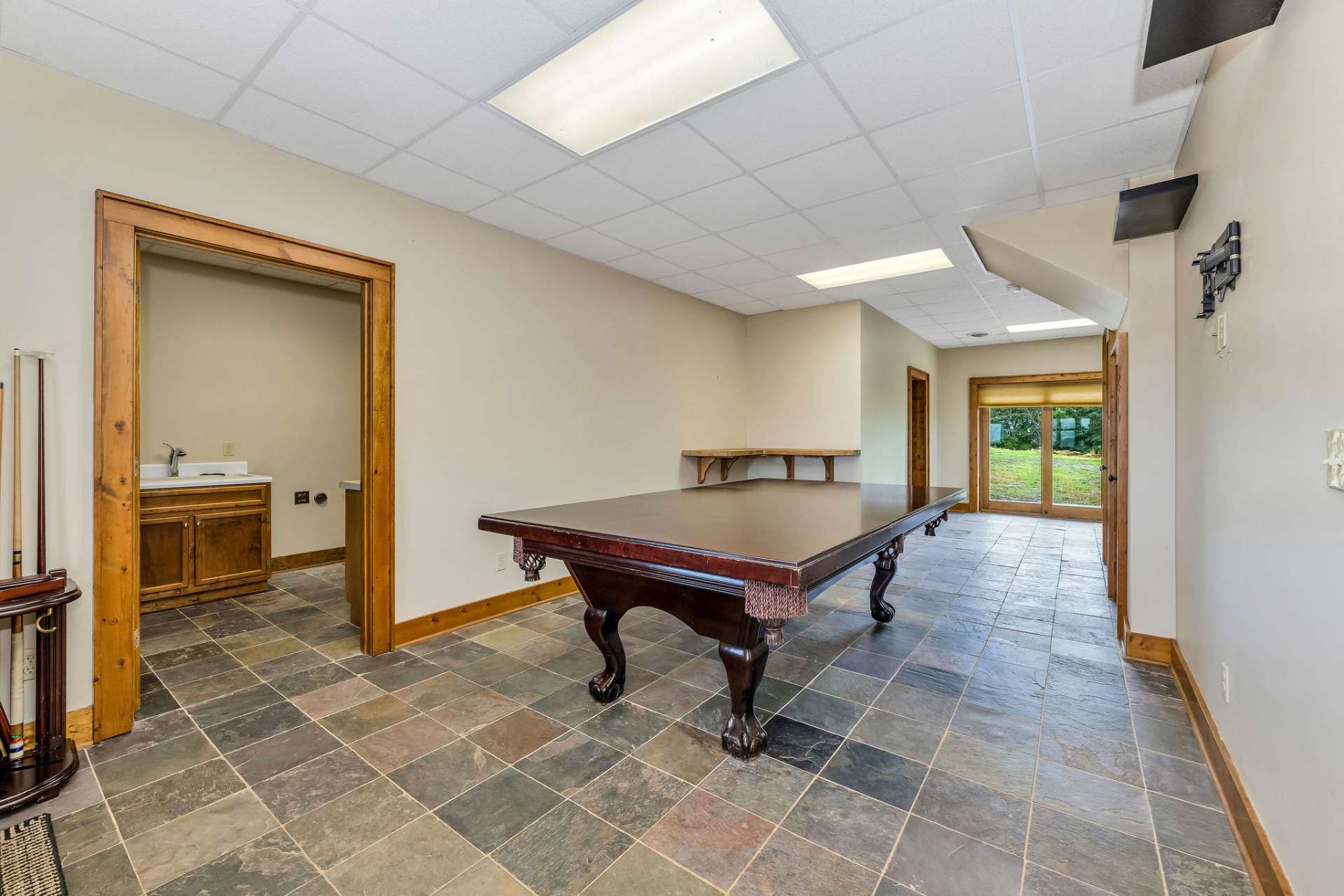 A view from the stairs into the game room into the oversized laundry room in the basement