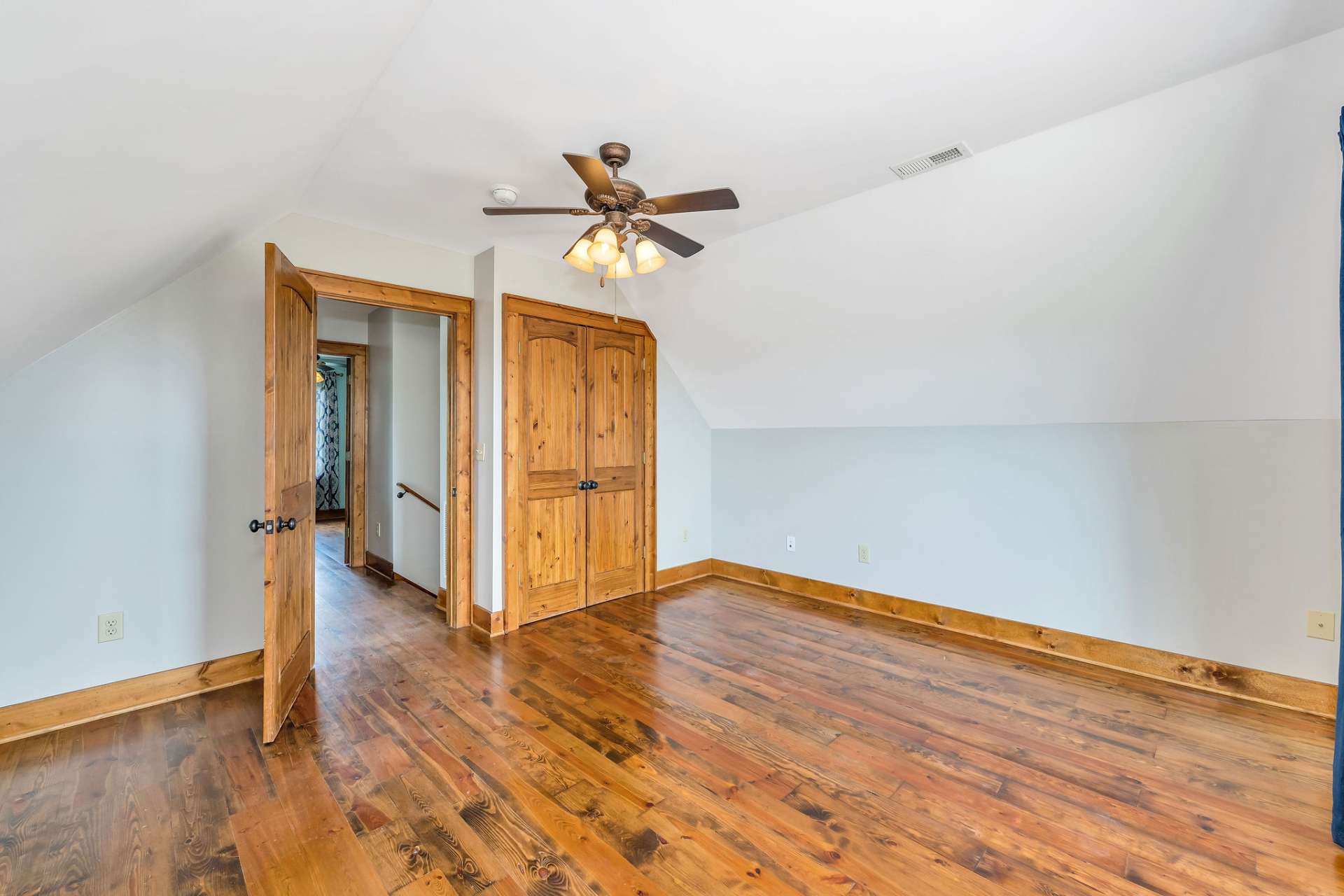 Upstairs bedroom with bronze ceiling fan and same quality hardwood flooring as the main level