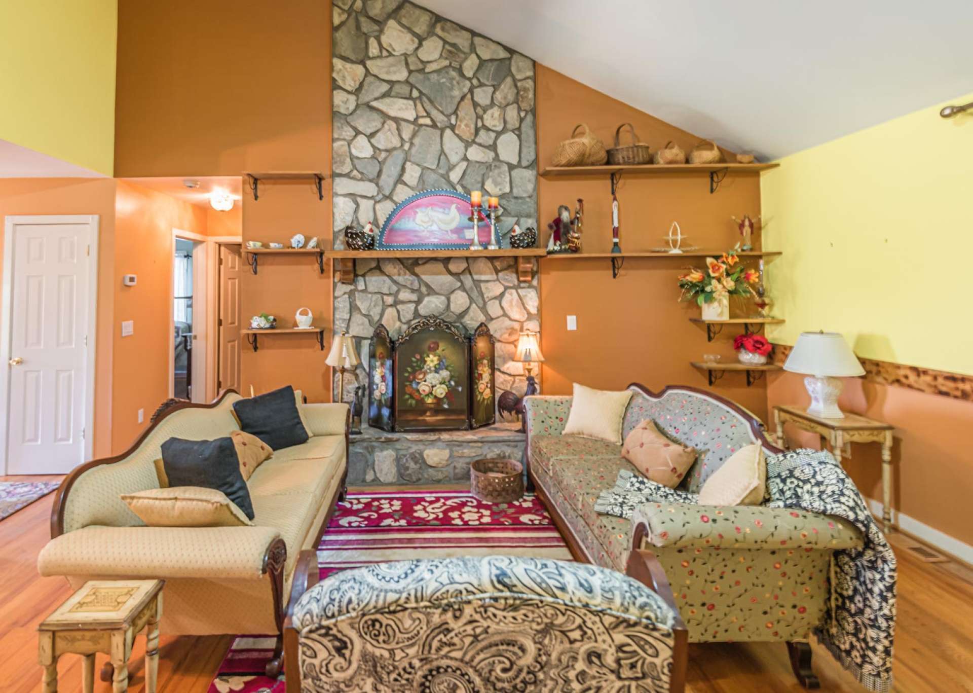 Offering one level living and an open floor plan, the great room is bright and cheery with vaulted ceiling, wood floors and a stone fireplace with gas logs.