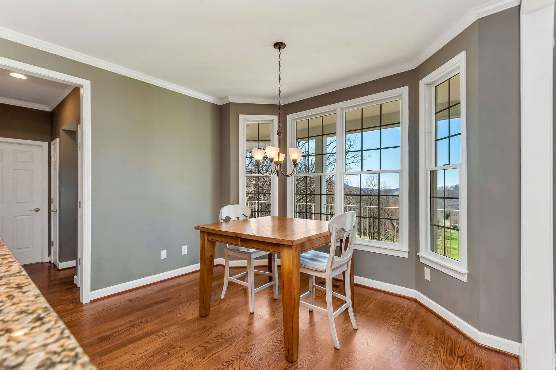 The charming breakfast nook is nestled adjacent to the kitchen and offers a picturesque view of the lush greenery of the golf course and the majestic peaks of the mountains beyond.