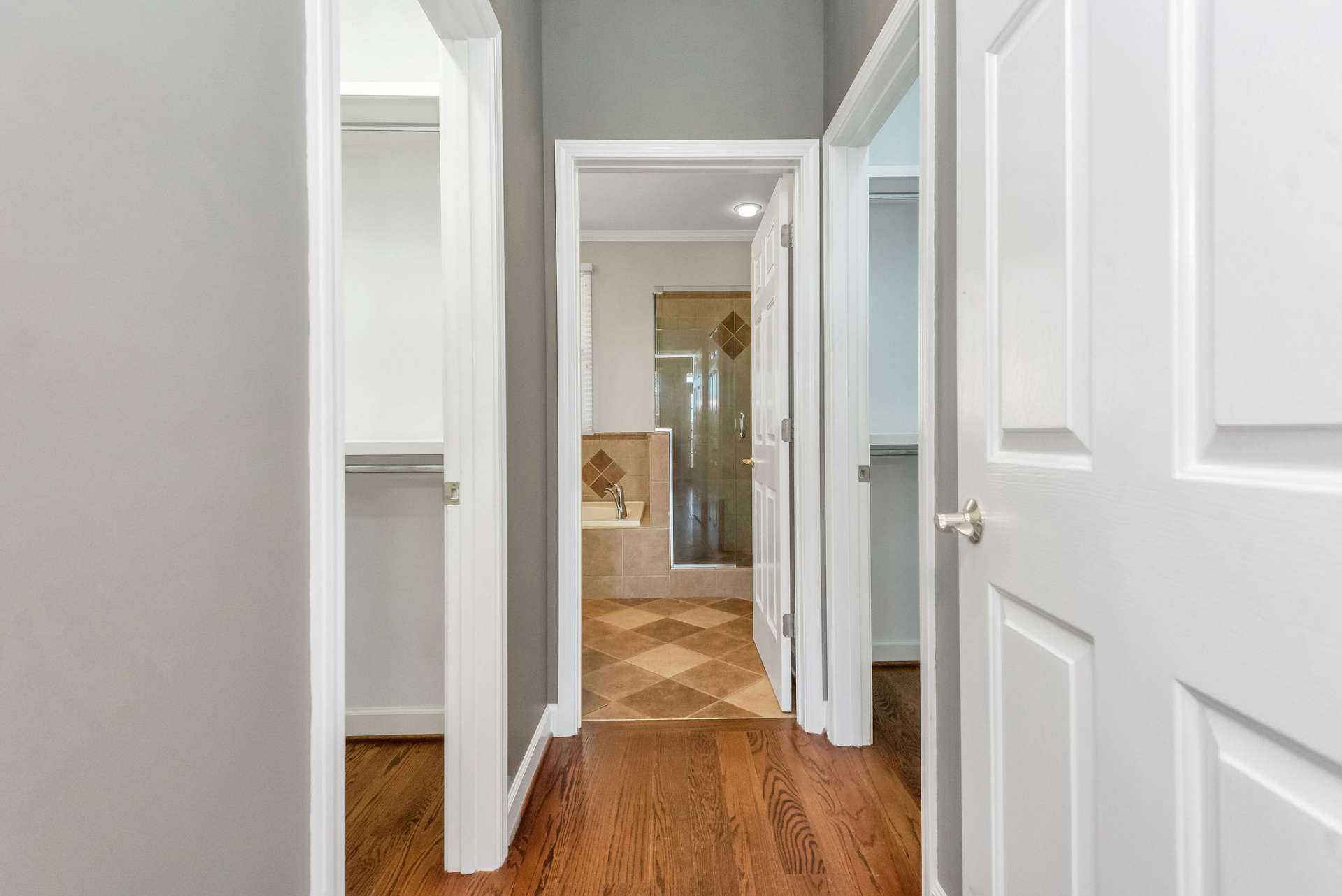 Passing through to the ensuite bath, you will find his/her walk-in closets on either side, providing ample storage for clothing, shoes, and personal belongings.