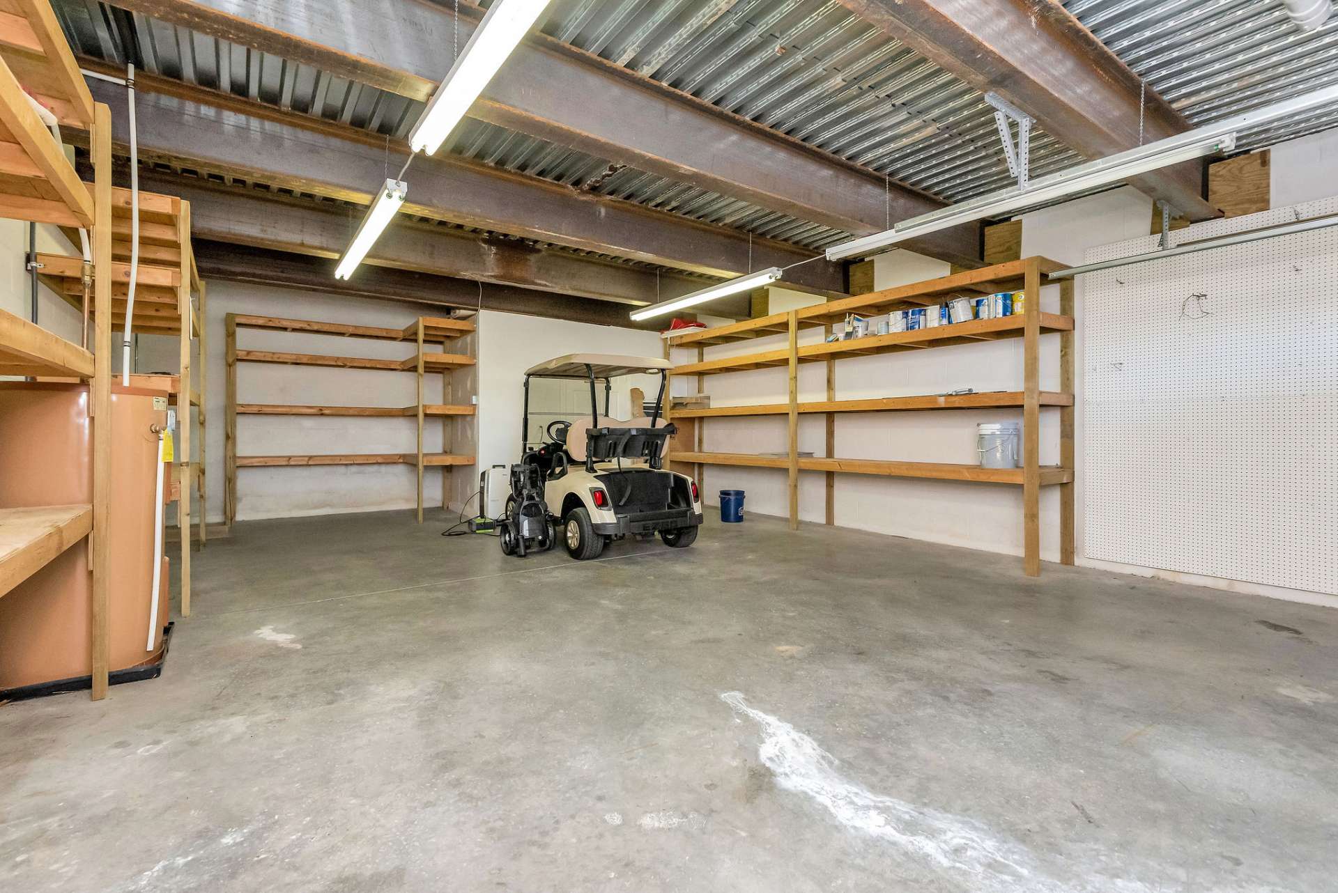 The lower level also provides this spacious storage area, including a cedar-lined closet, and a garage door specifically designed for a golf cart. This convenient feature provides secure storage and easy access for your outdoor equipment and toys, as well as your golf cart, protecting it from the elements and ensuring that it's always ready for your next round on the course.