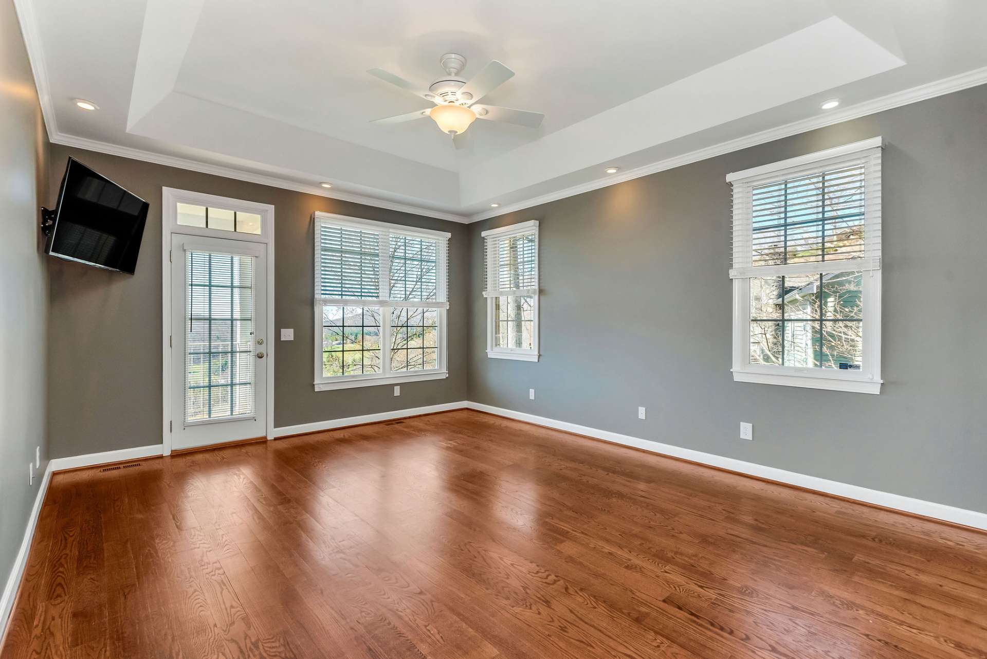 The luxurious primary bedroom is a serene retreat designed for ultimate comfort and relaxation. A glass door provides access to the rear deck, adding to the natural light and offering a seamless transition between indoor and outdoor living.