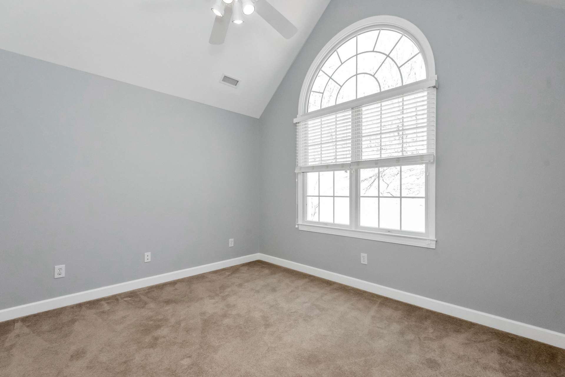 Upper Level Bedroom #3 - Another comfortable and inviting bedroom featuring soft carpeting underfoot and an elegant arched window, which floods the space with natural light and offers a charming view on the front side of the home. Includes walk-in closet.