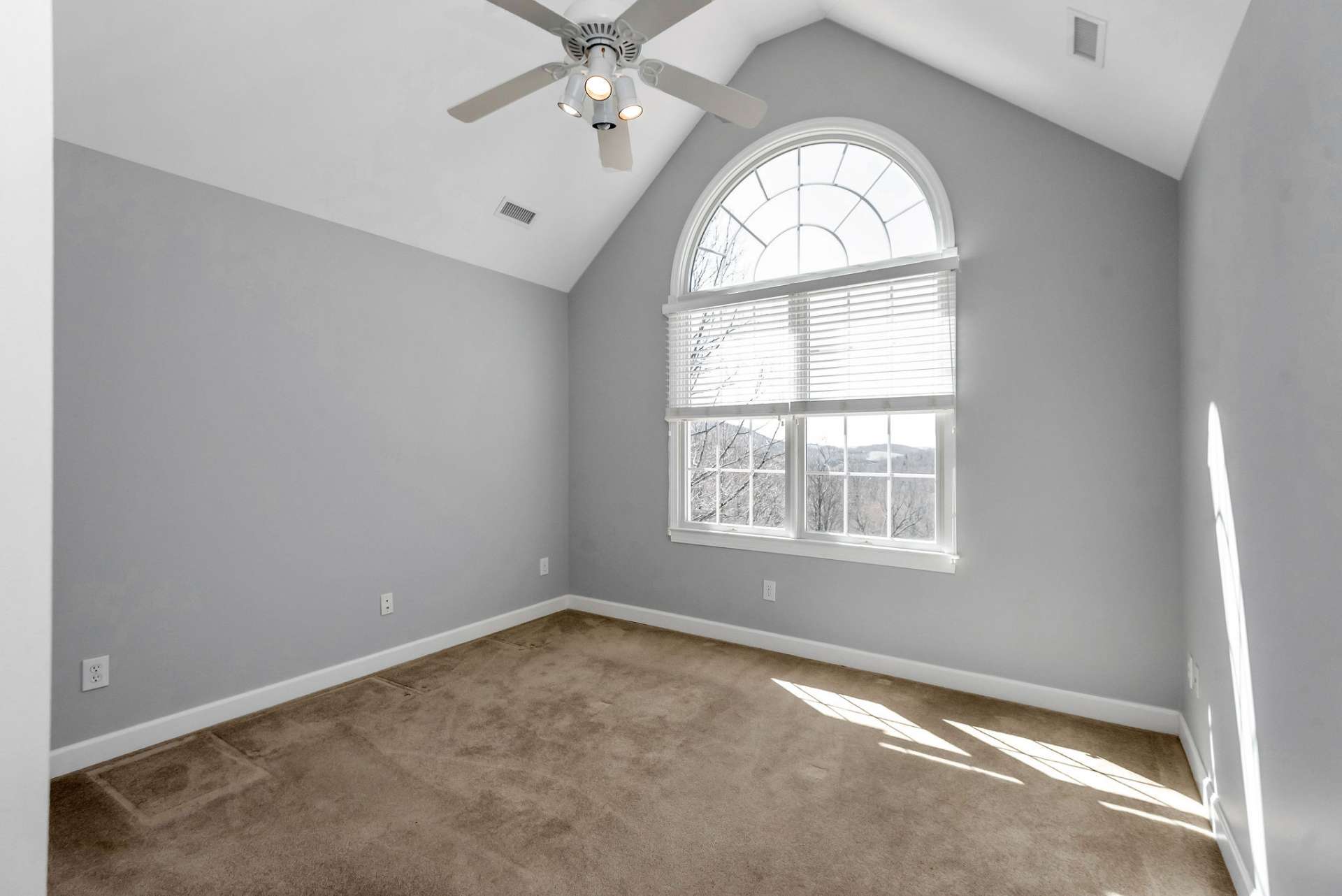 Upper Level Bedroom #2 - A tranquil haven also offering soft carpeted floor and large arched window, framing a stunning vista of the lush green fairways and manicured landscapes beyond.