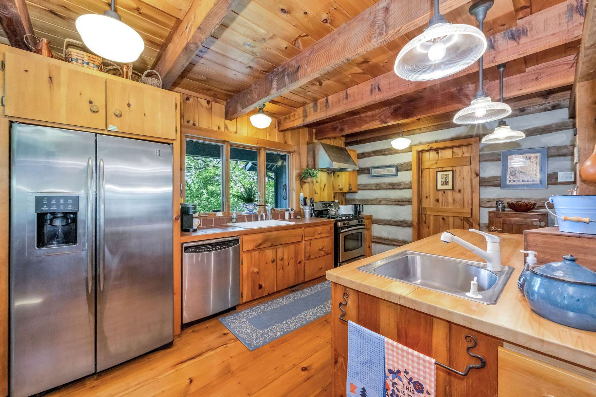 Sleek stainless appliances, including a gas range with a vented hood.