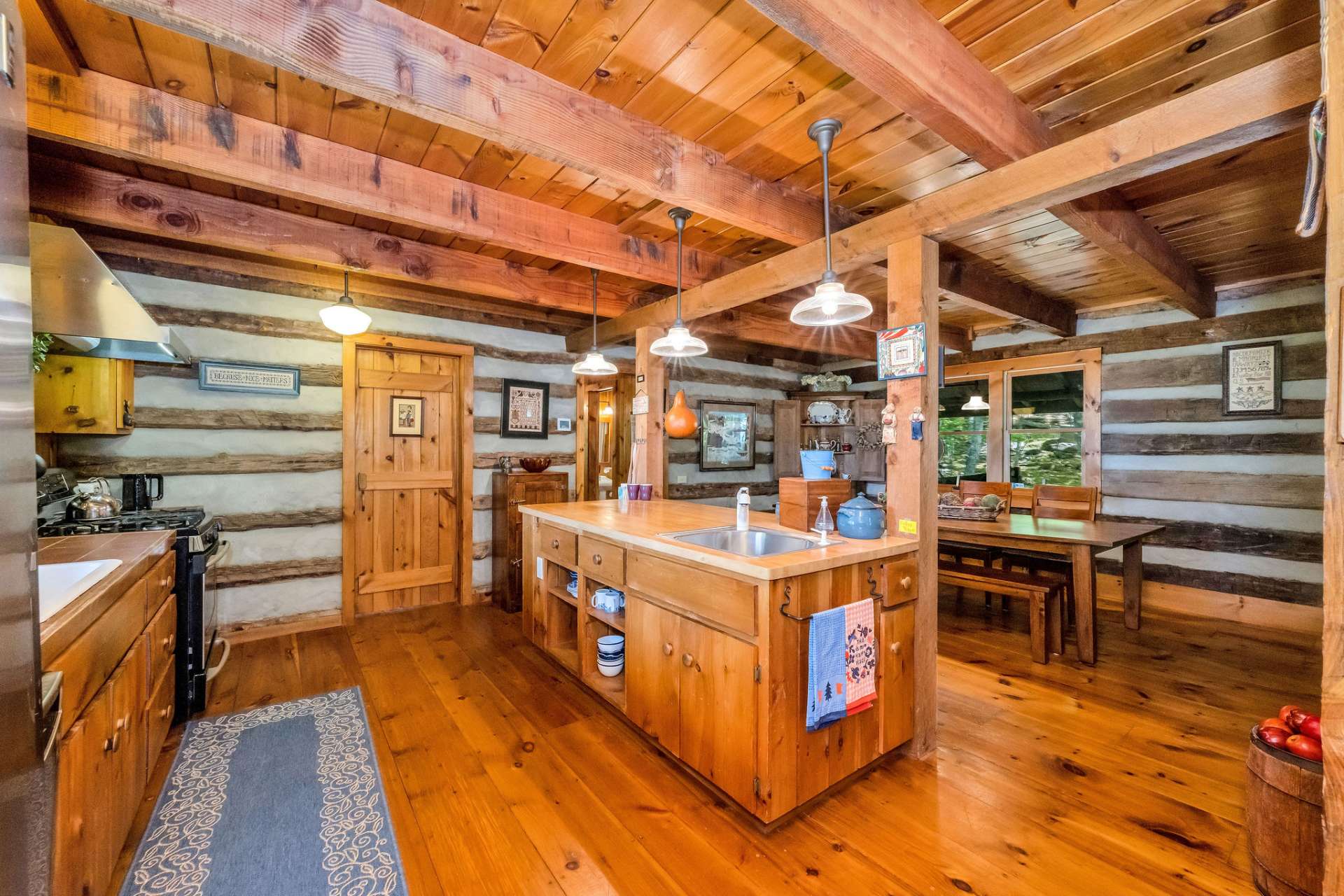 The spacious kitchen island serves as a central hub with space for prepping meals, storing essentials, gathering for casual bites, and includes an extra sink for functionality.