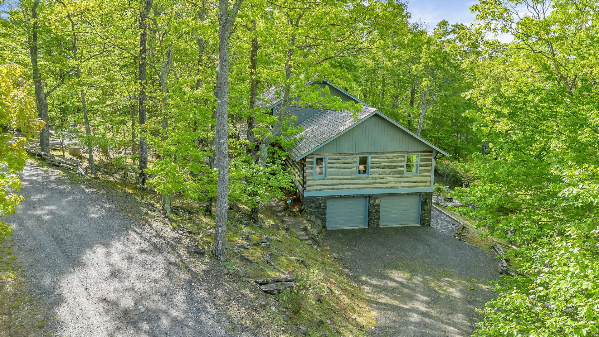 A circular driveway up top provides convenient guest parking, while a lower drive offers direct access to the garage.