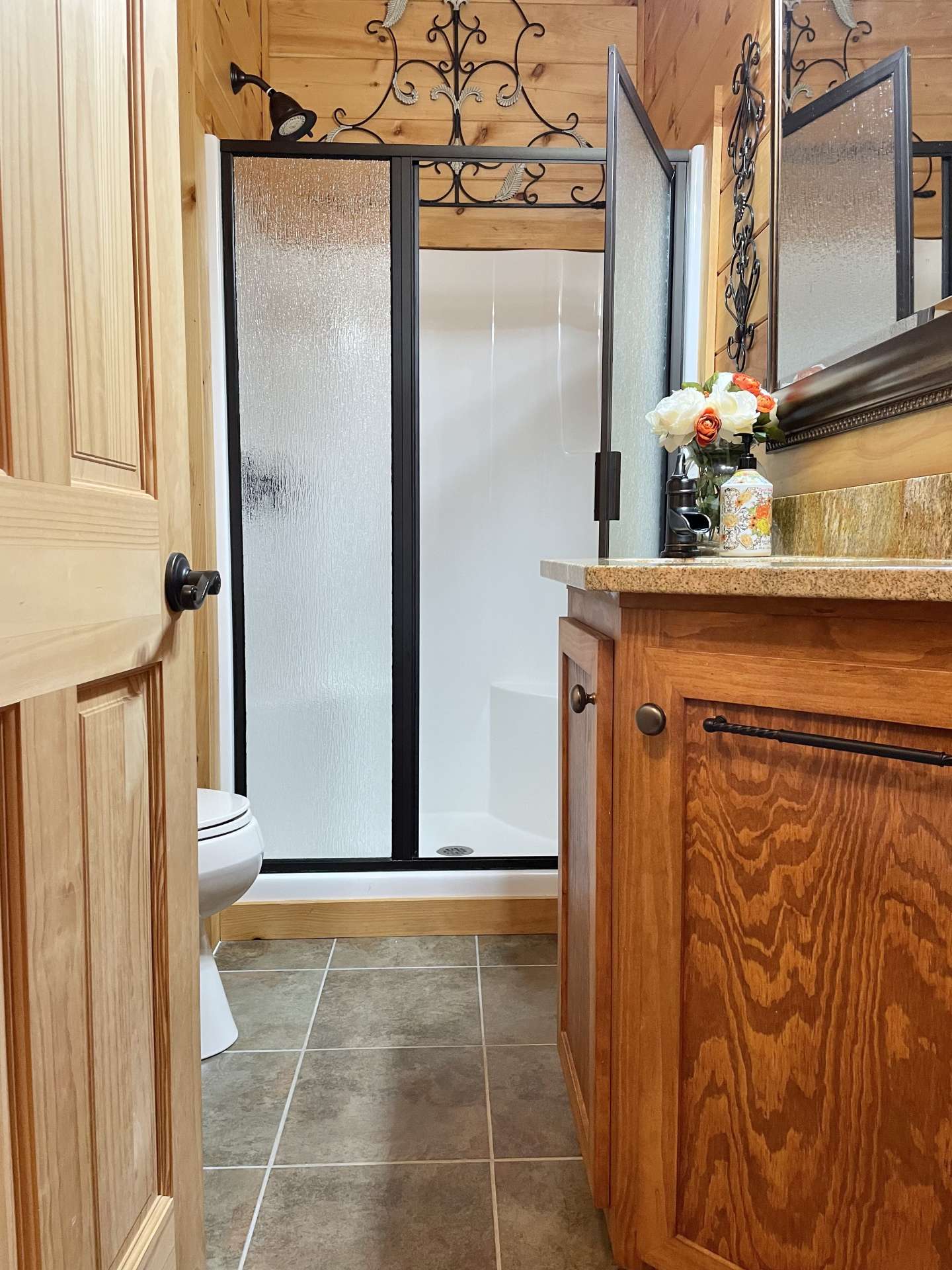 Upper level bath with granite countertop and glass shower doors.