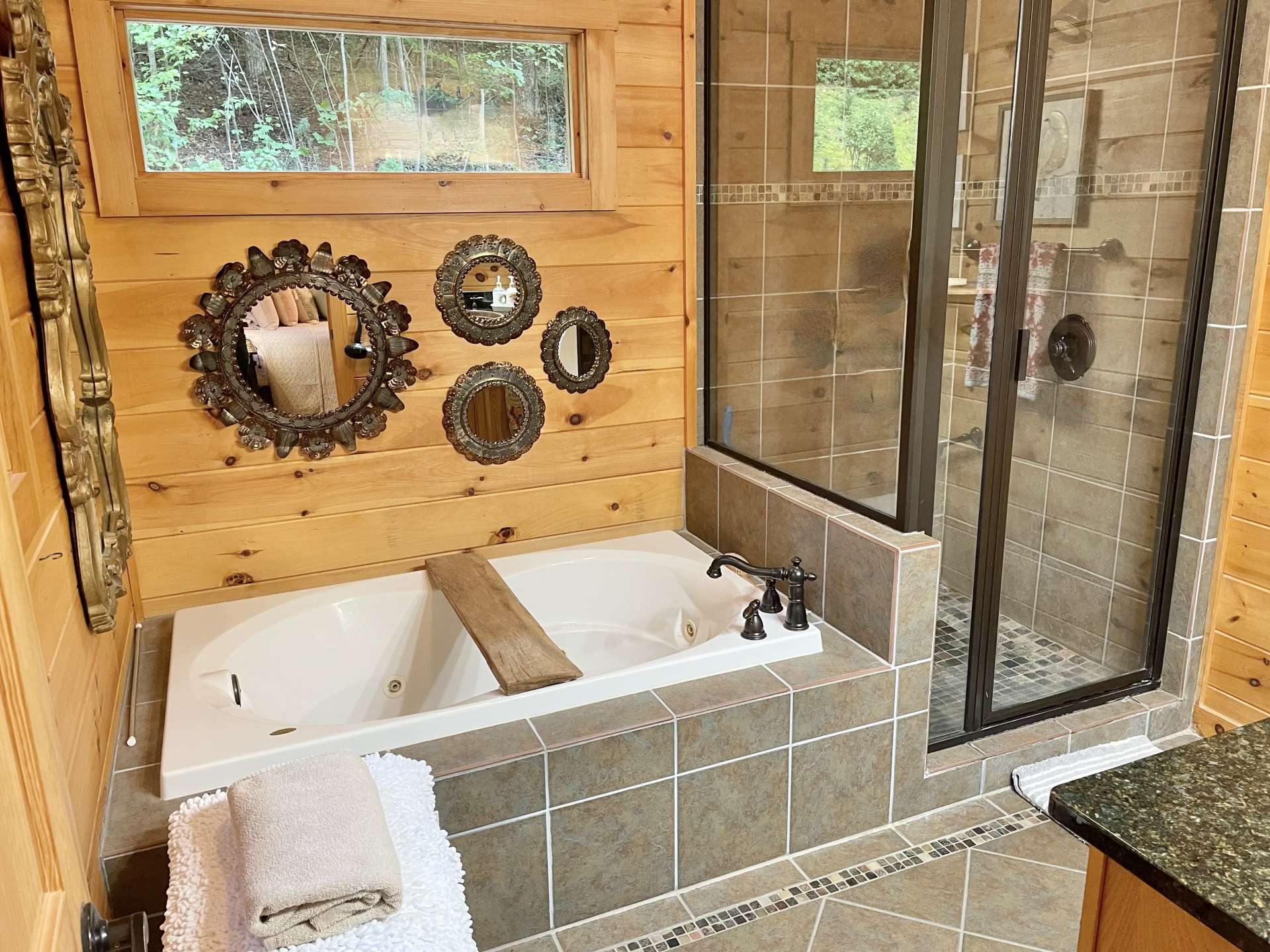 Primary bath with soaking tub and glass enclosed shower.
