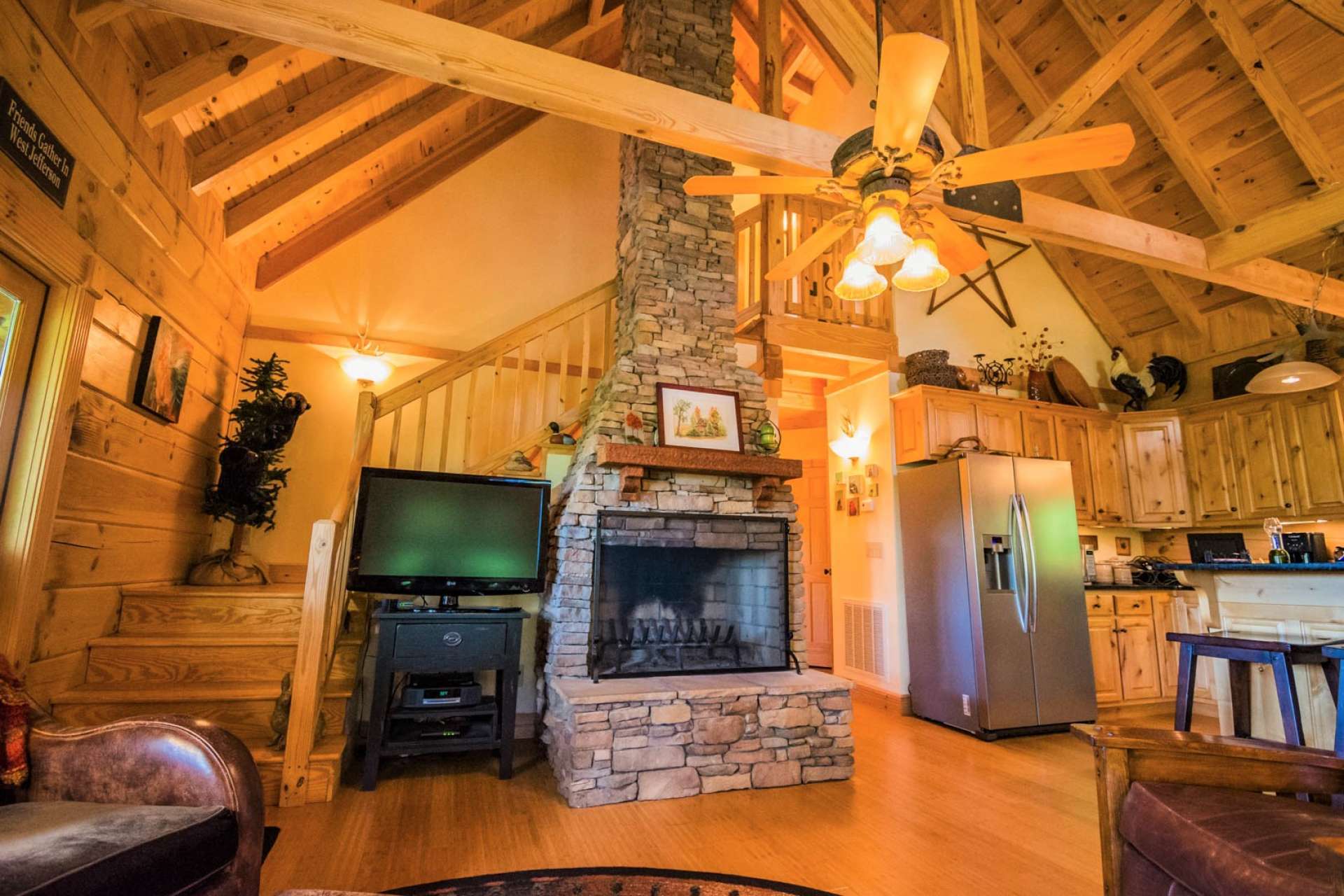 This photo shows the majesty of the fireplace and vaulted wood ceiling. Also, notice the Bamboo wood flooring creating a warm glow.