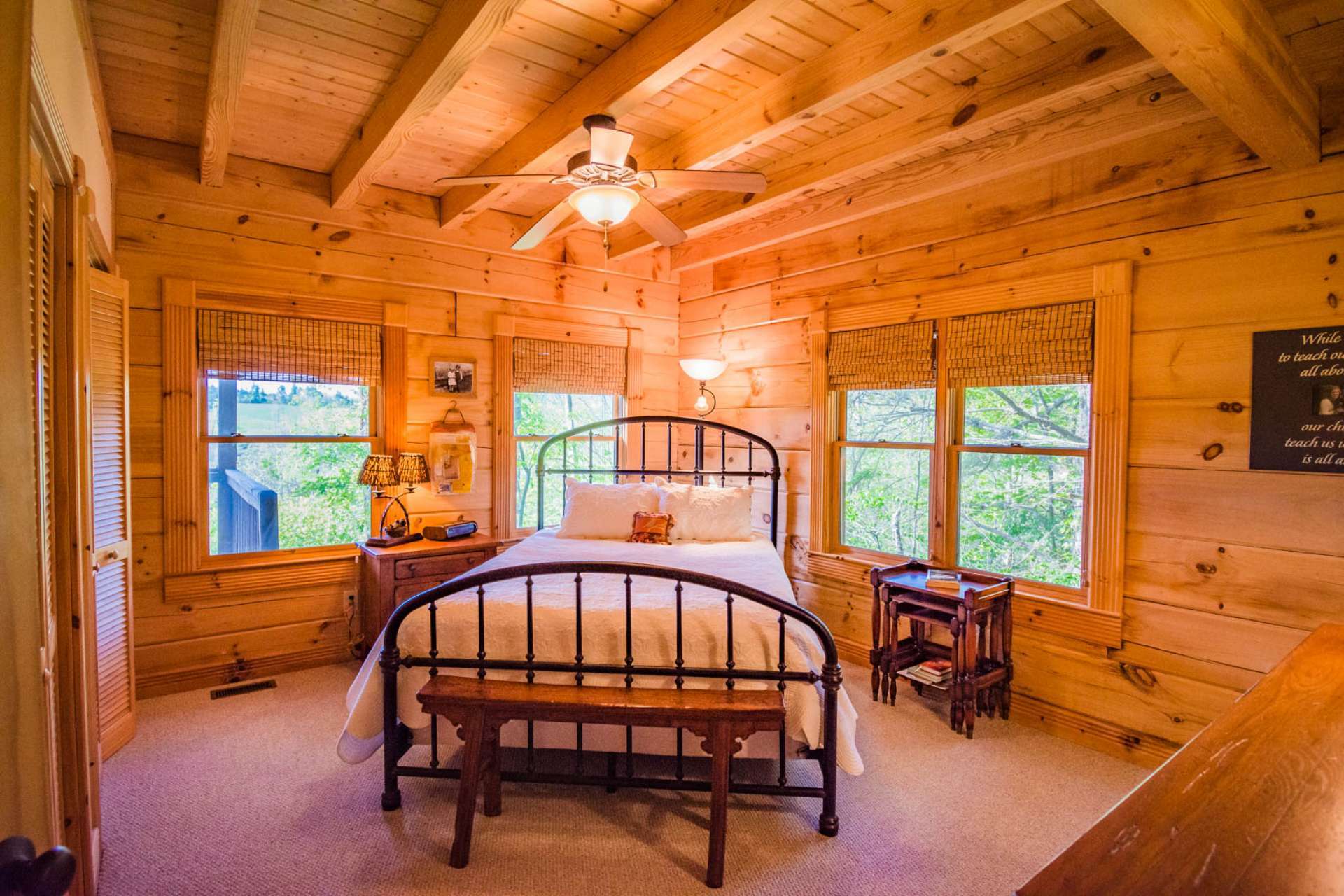 The main level master suite features lots of windows, exposed beams, comfortable carpeted floor, and a private bath.