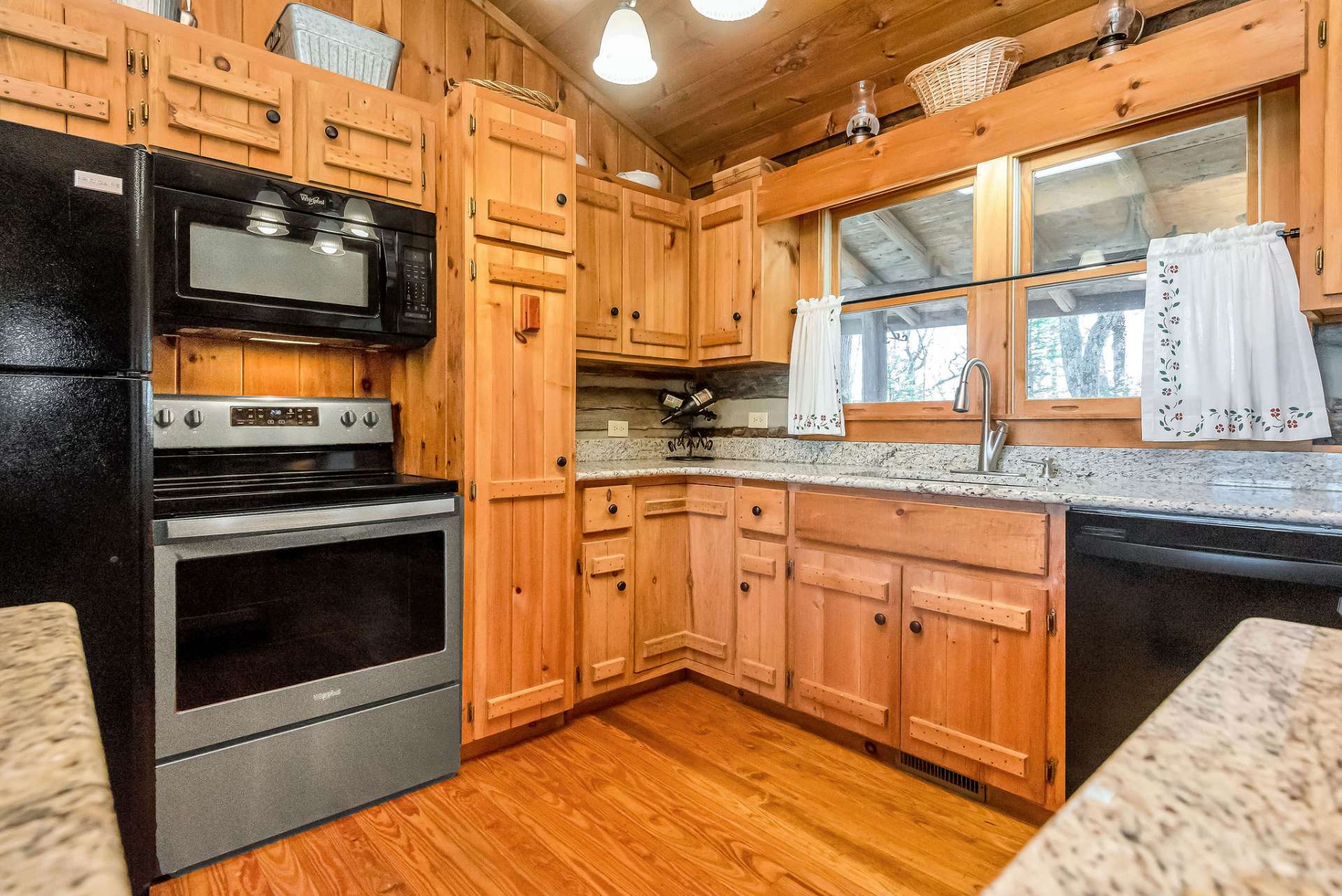 Custom cabinets with pull-out shelves and pantry exude rustic charm.