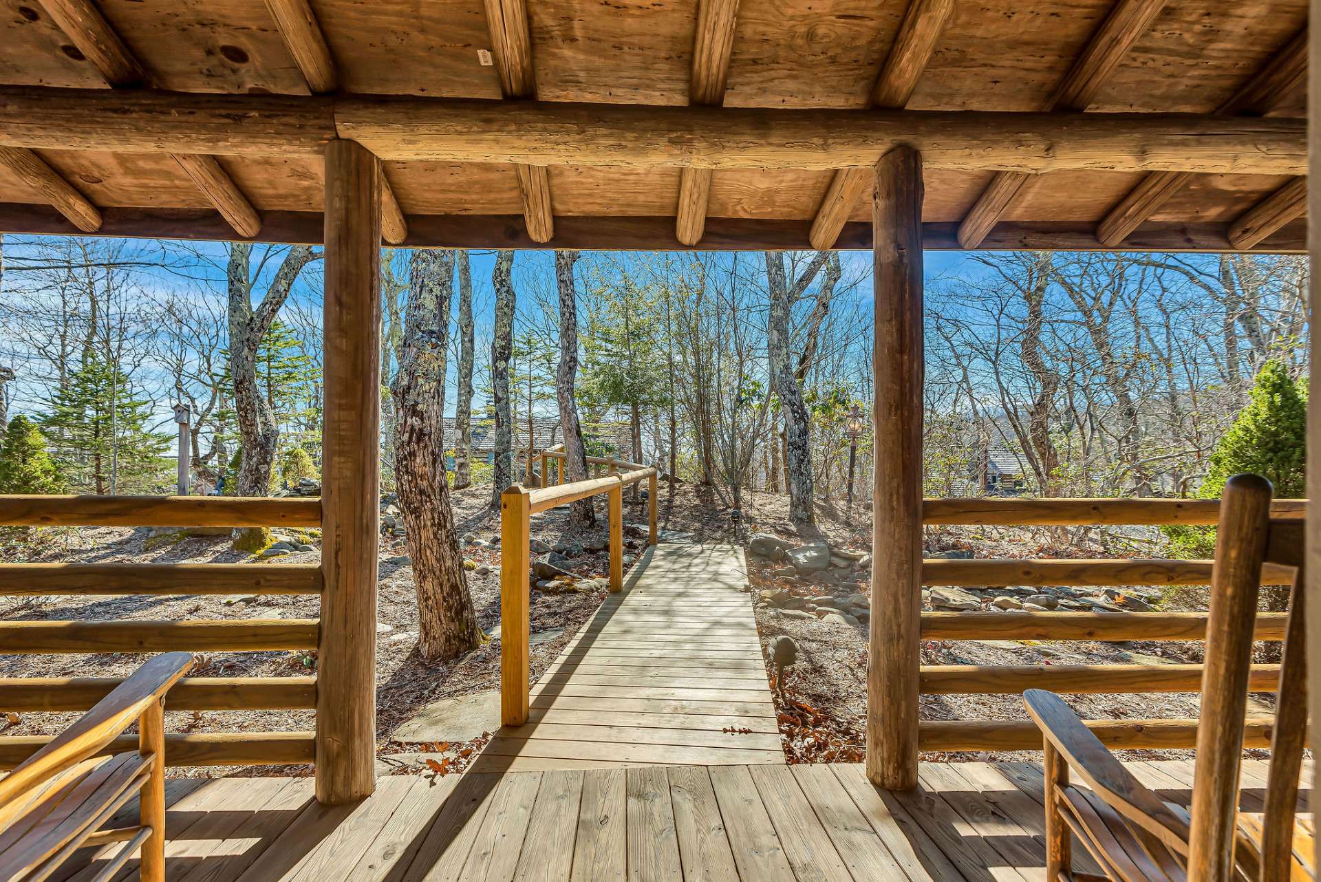 The covered front porch leads to a natural landscaped setting.