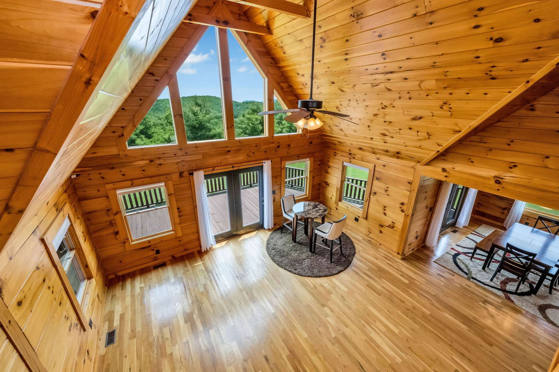 From the open walkway connecting the upper-level bedrooms, you can look down into the living area below and through the wall of glass that showcases incredible mountain views.