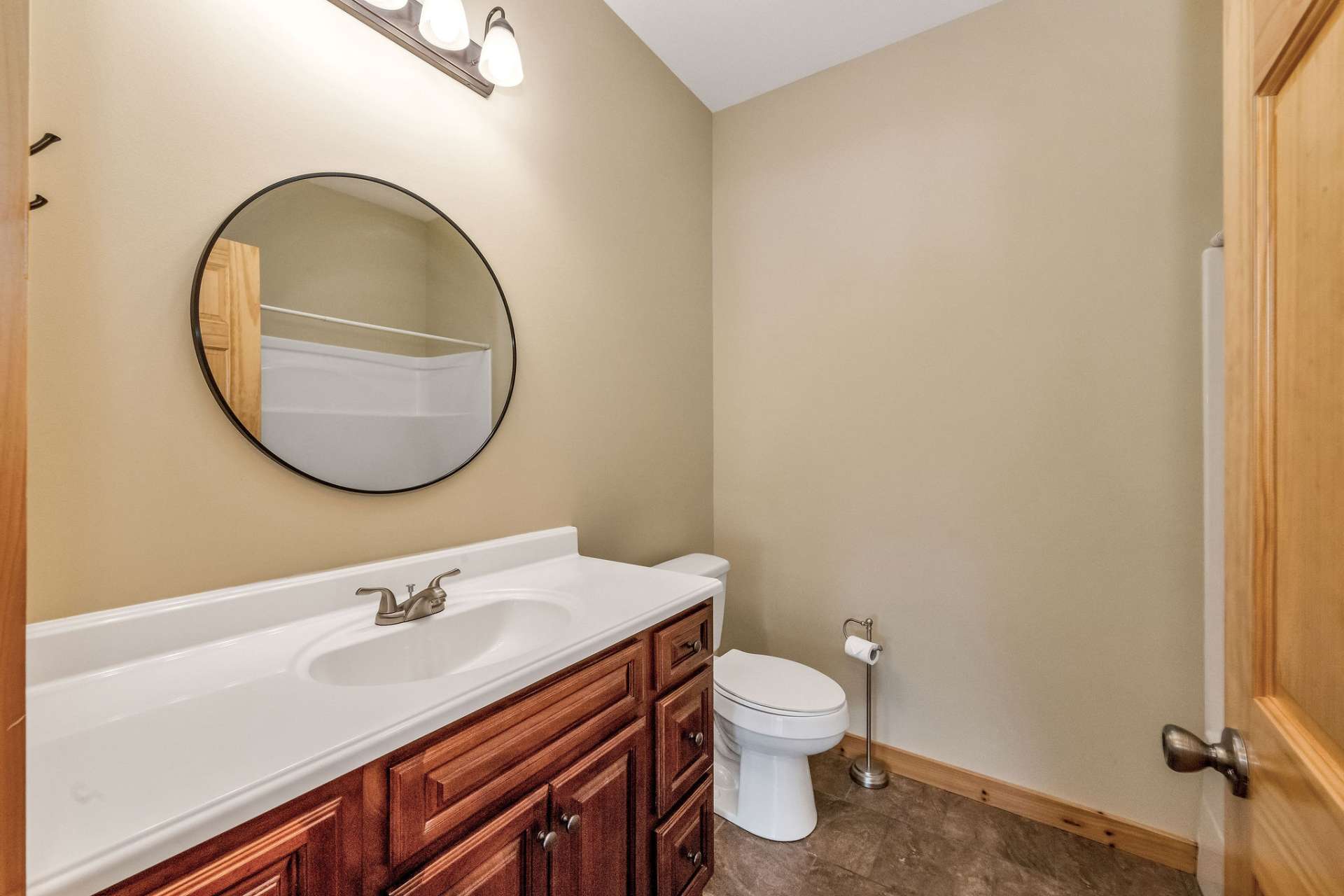 This full bath also features easy-care ceramic tile flooring, a fiberglass tub/shower combo, and a warm cherry vanity.