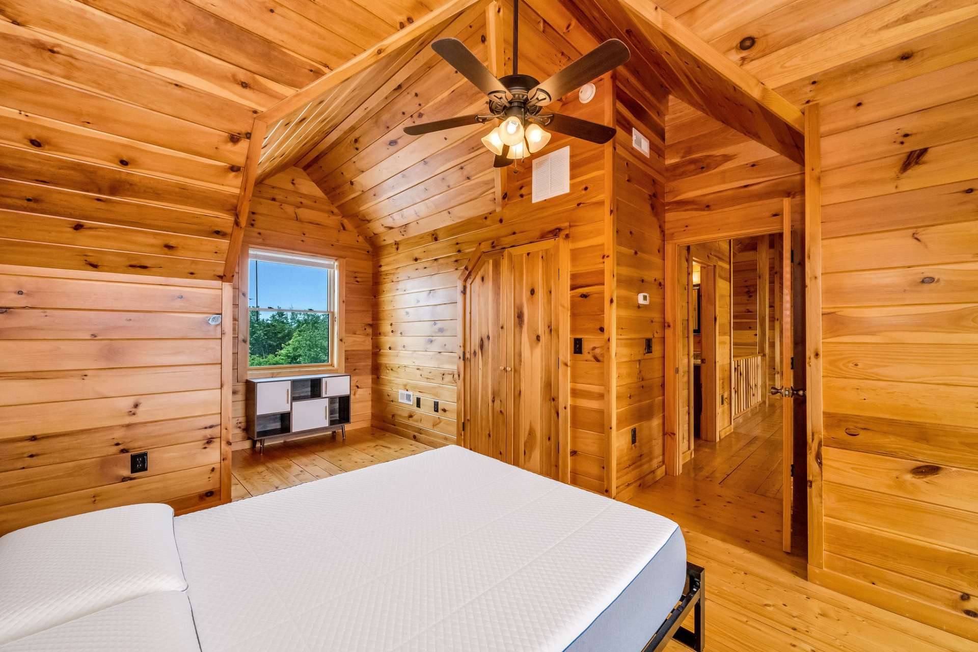 Striking rooflines and rich wood finishes give this bedroom unique architectural character, blending rustic charm with design-forward appeal.