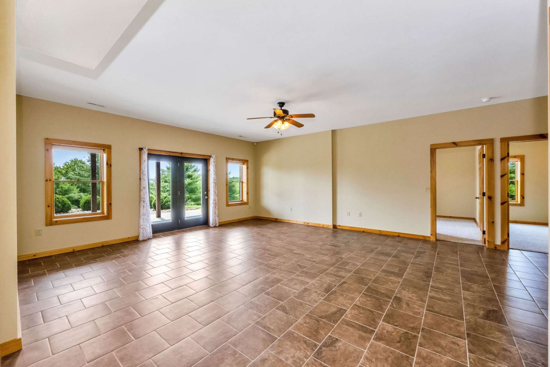 The expansive lower-level family room features durable ceramic tile flooring and plenty of space for relaxing or entertaining.