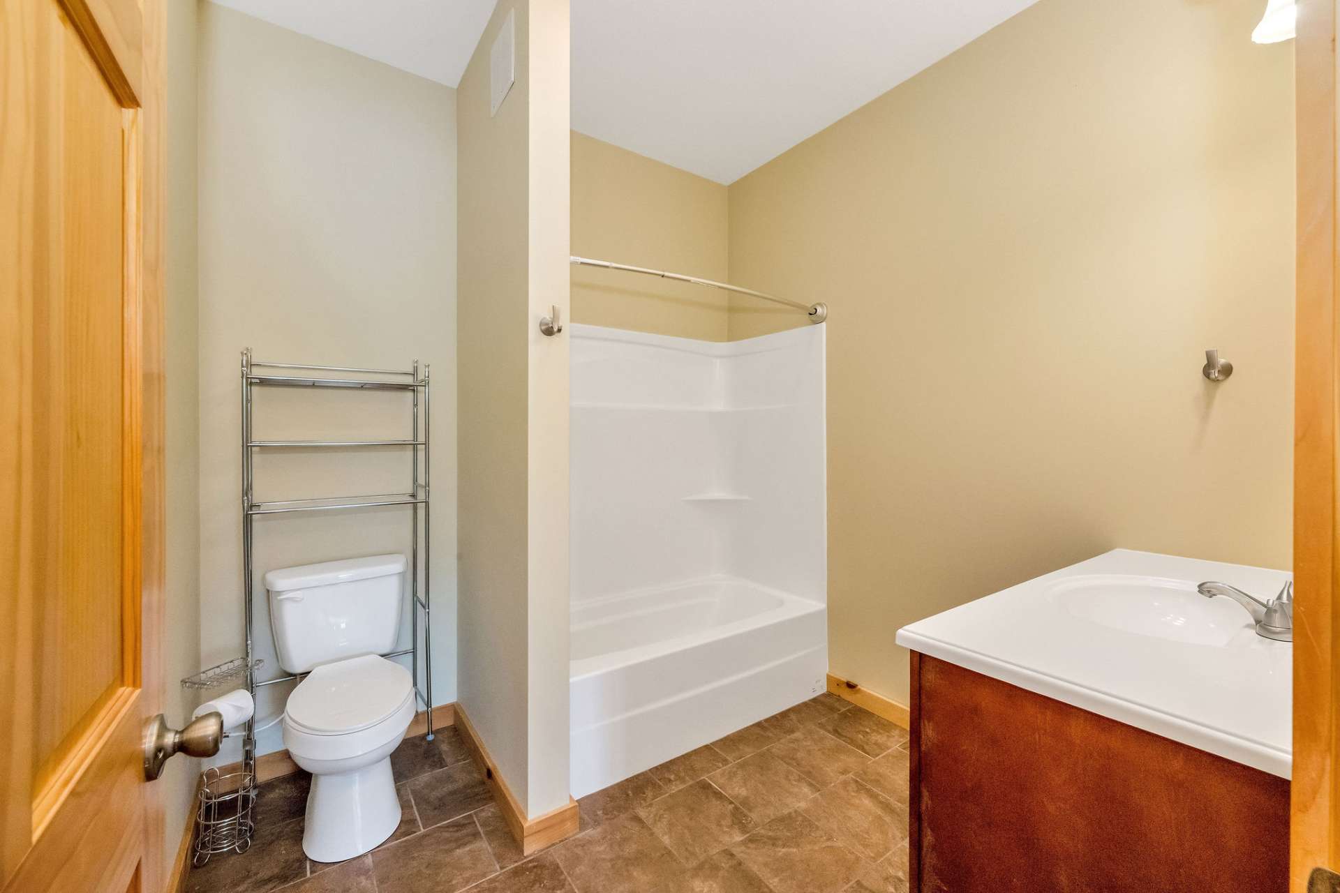 This spacious en suite bath features durable ceramic tile flooring and plenty of room to move comfortably.