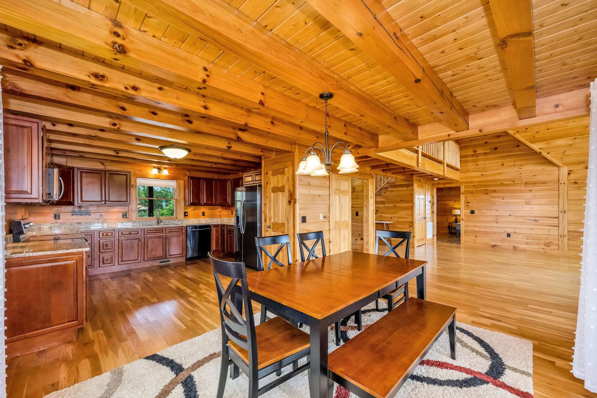 Exposed beams and tongue-and-groove ceiling add warmth and character, enhancing the inviting mountain style of the space.
