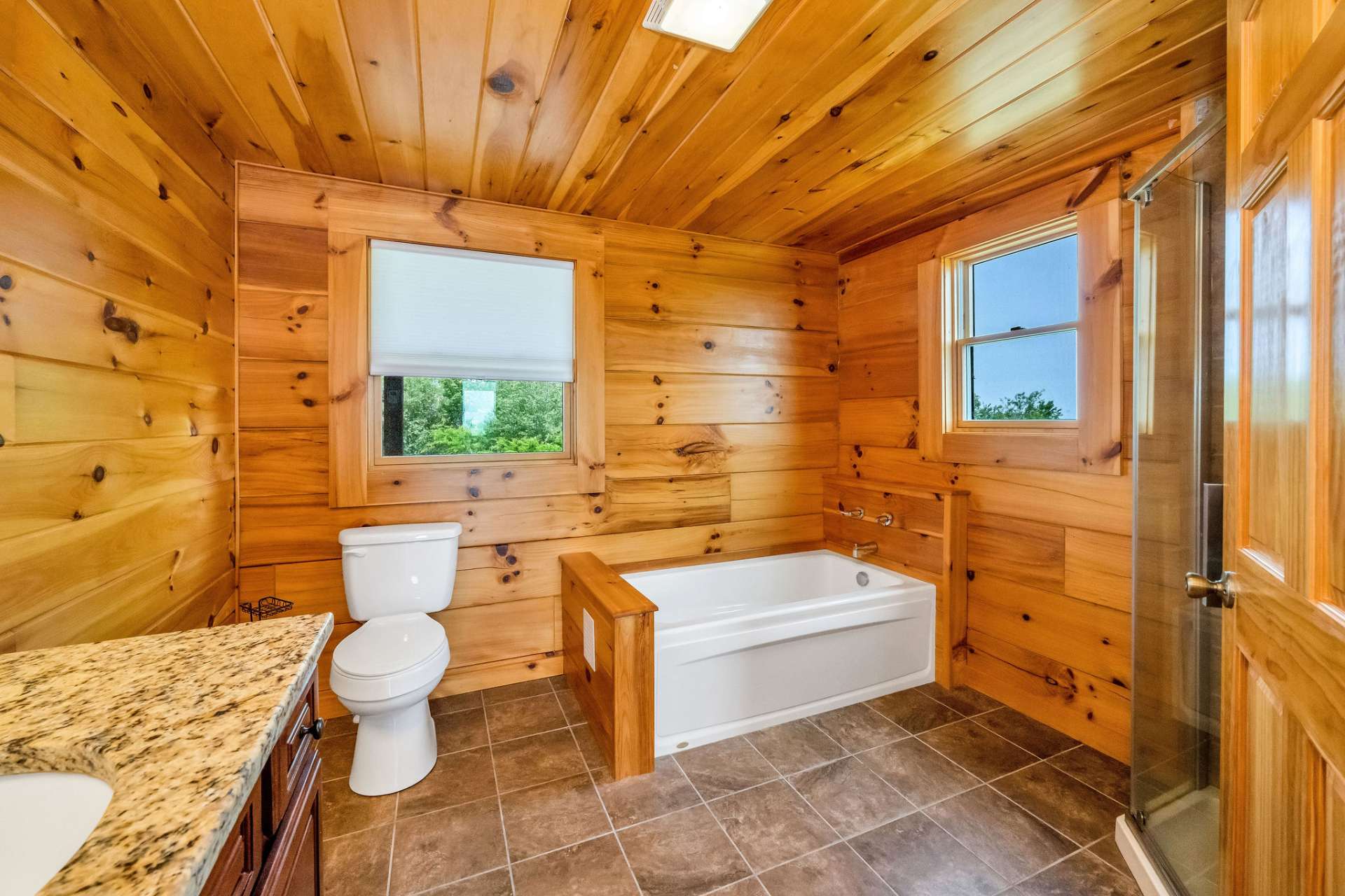Step into the spacious en suite bath, where ceramic tile floors and soft natural light create a clean, calming atmosphere.