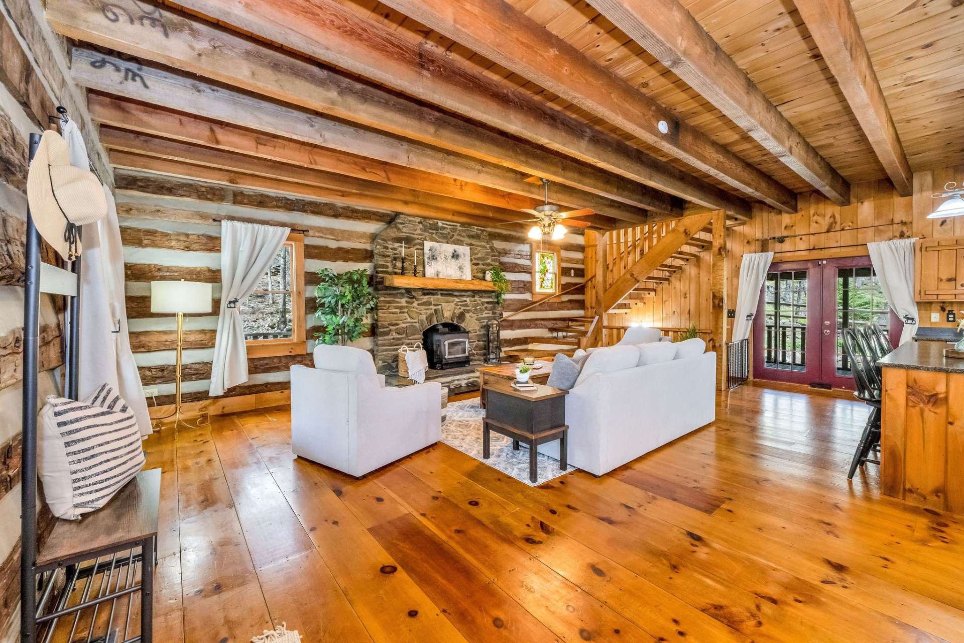 Step inside to an expansive great room with a native stone fireplace, a 9 foot high beamed ceiling and wide plank wood flooring.