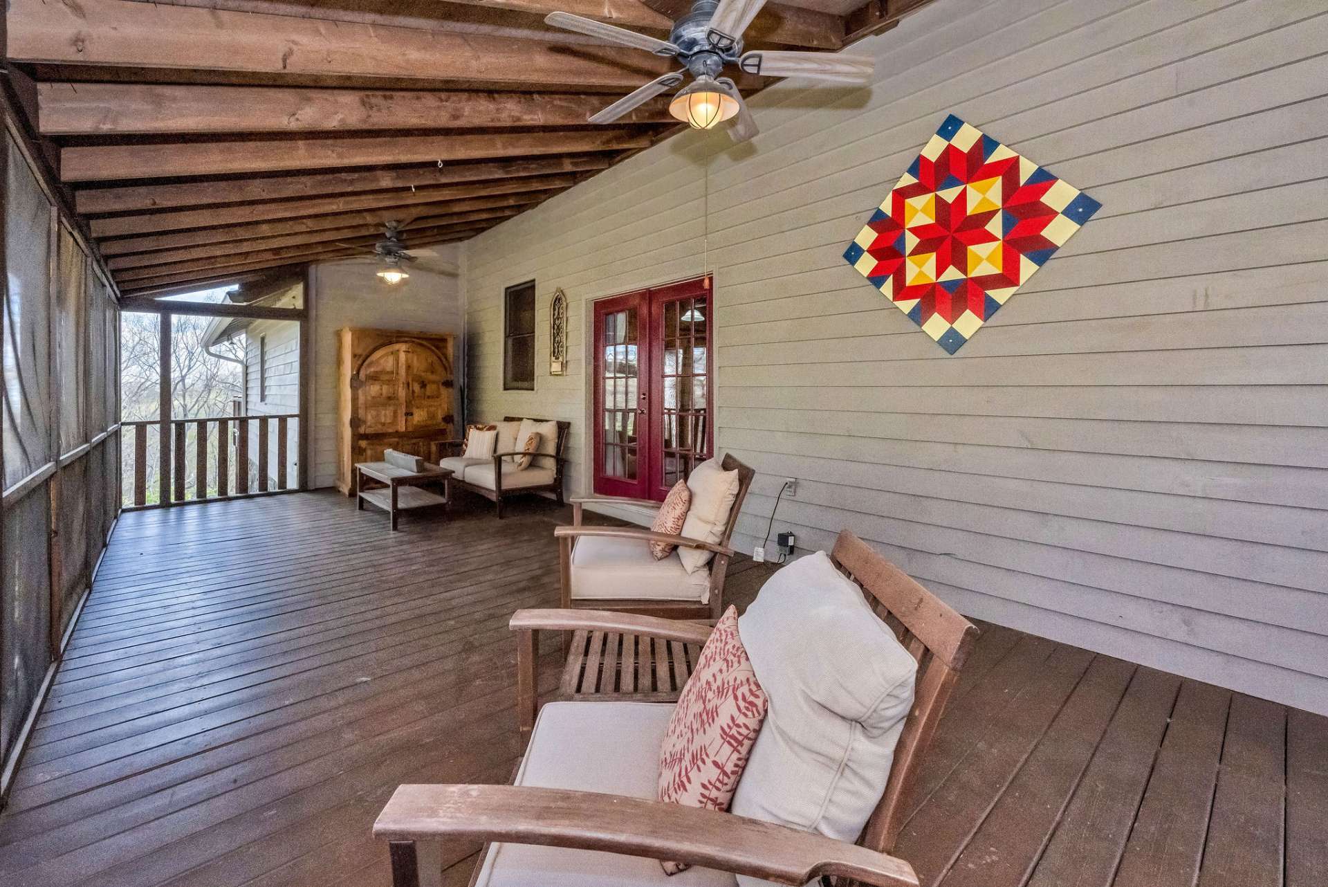 Two ceiling fans and barn art add comfort and character to your outdoor living room!