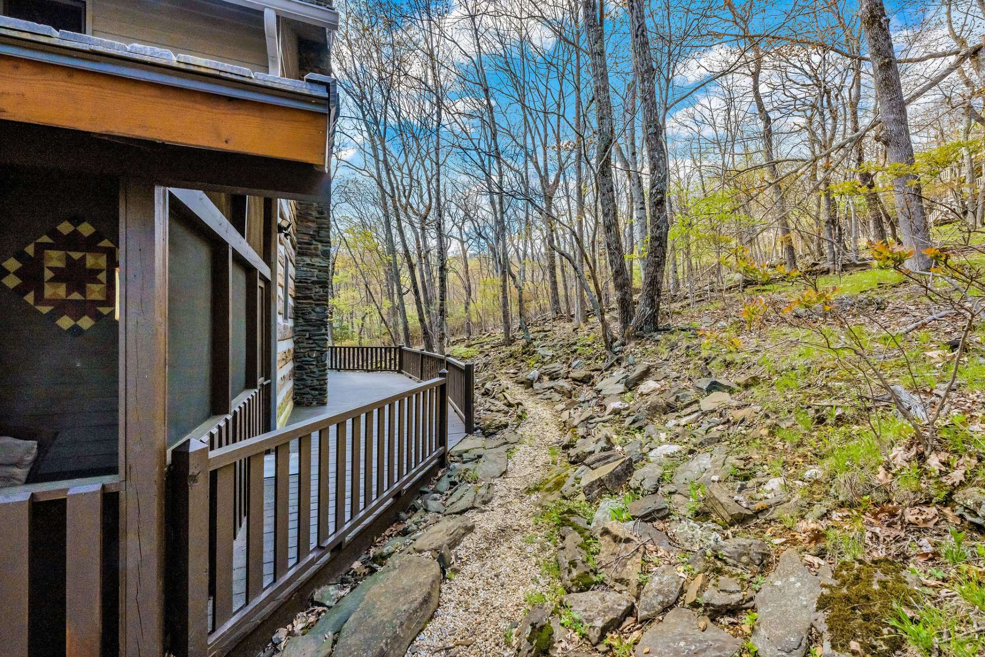 The natural landscaping includes mature trees and rock outcroppings.