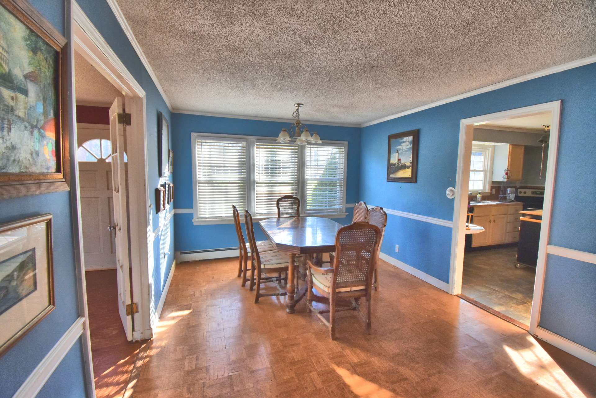 A spacious light filled dining room has a parquet wood floor and easy access to and from the kitchen and living rooms.