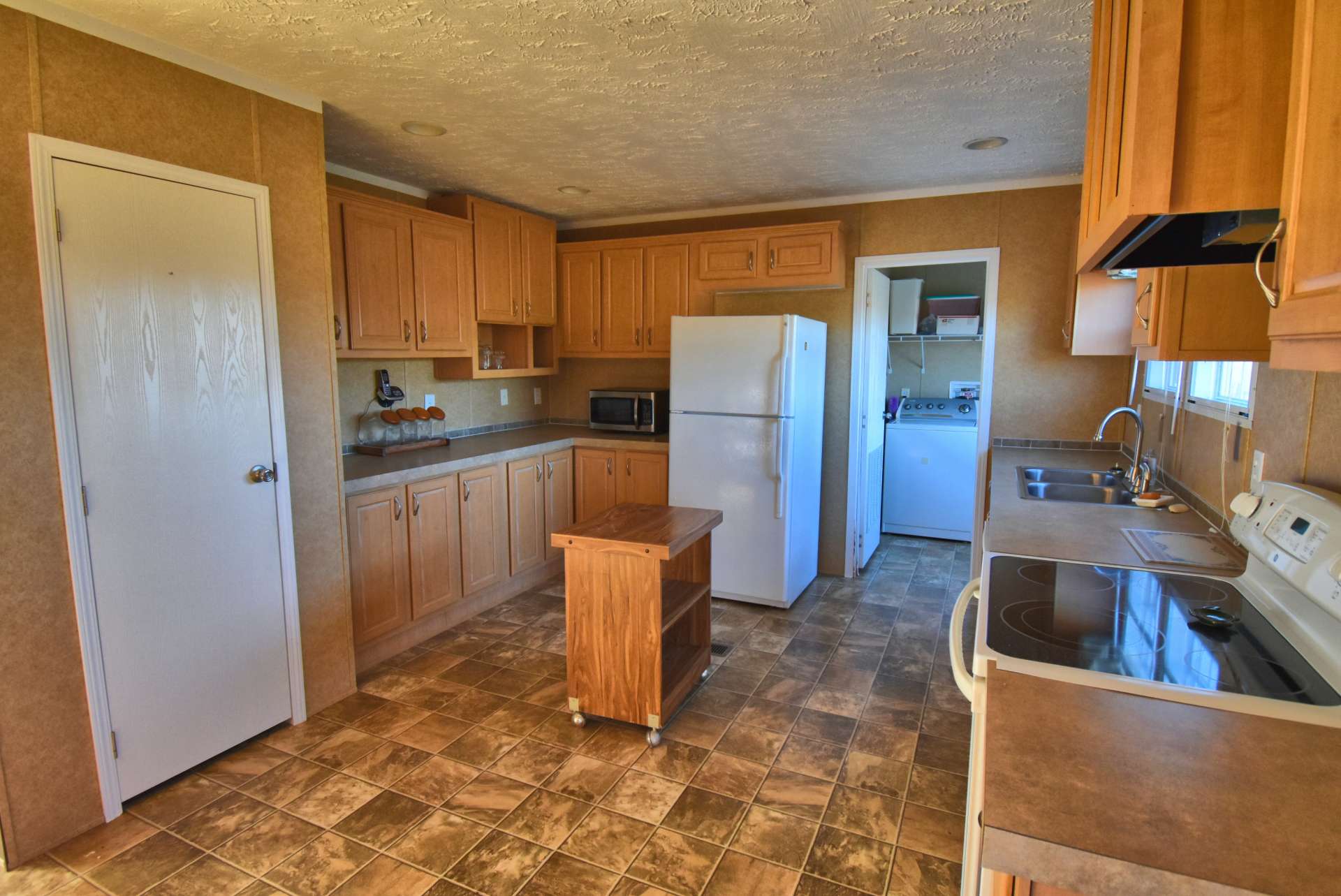 Plenty of work and storage space in the kitchen that also accesses the laundry/utility room and the back deck.