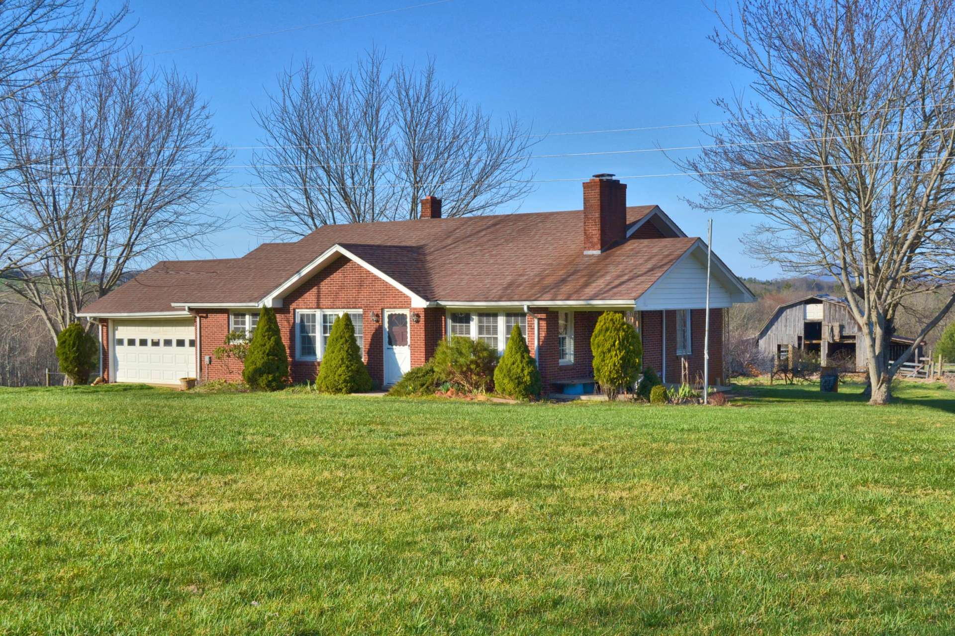 The first home is a charming 2-bedroom, 1-bath brick farmhouse with attached garage and easy access.