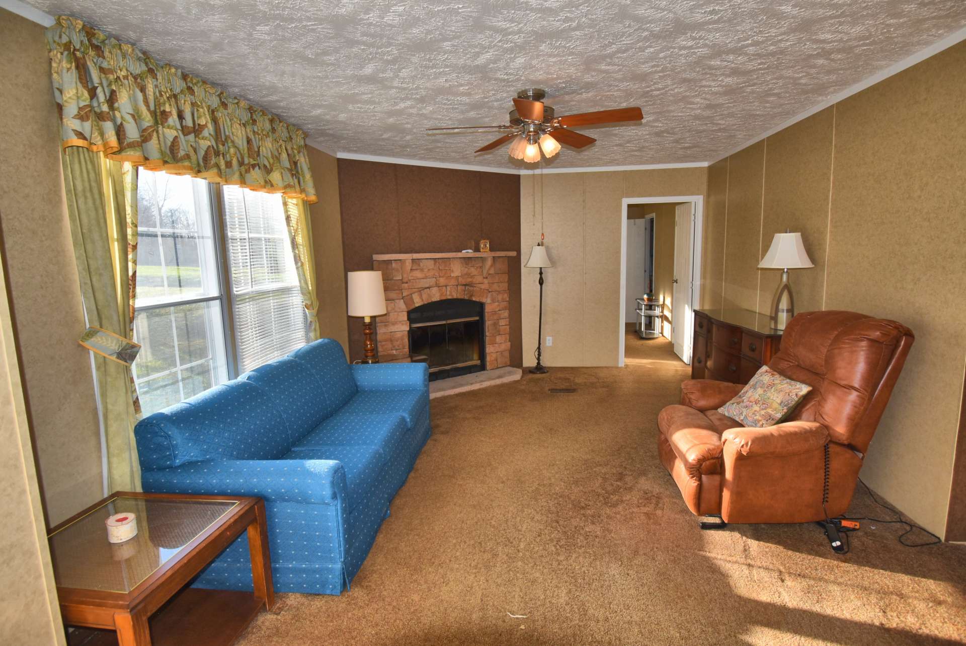 The spacious living area features a fireplace, currently blocked, but can be opened back up for use if desired.