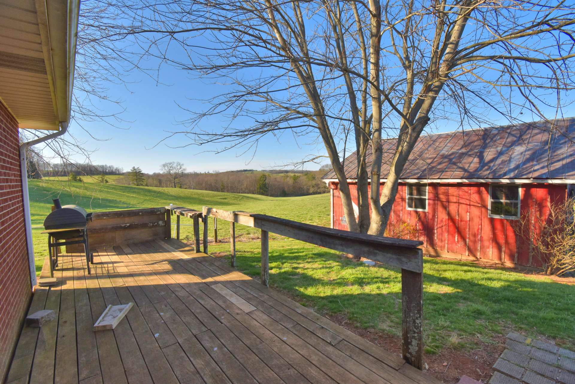 In need of some TLC, the back deck overlooks pastures, barns, and views.