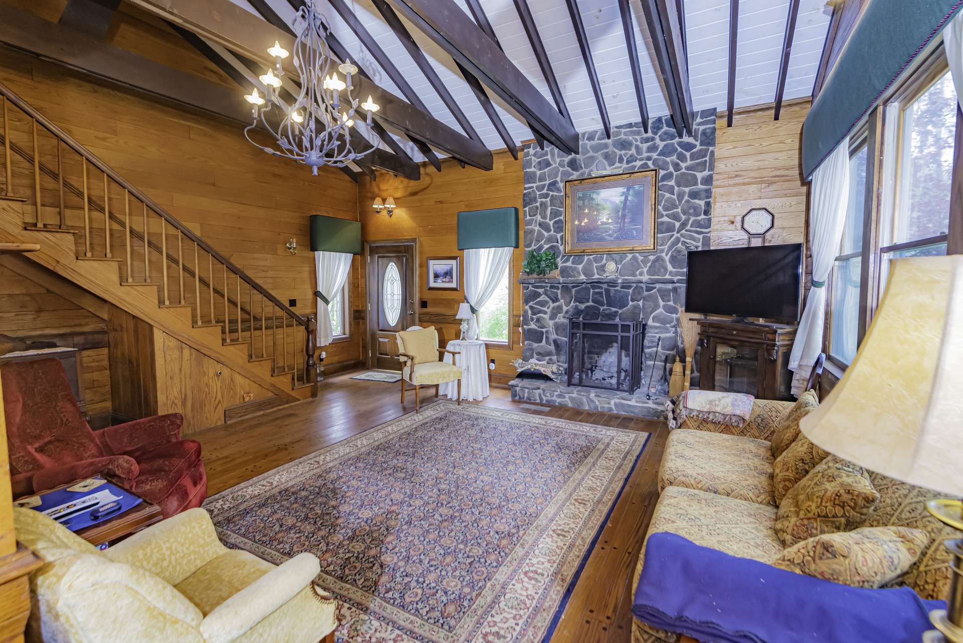 A large living area welcomes you soaring cathedral ceiling, exposed beams, lots of windows for natural light, and a stone fireplace for relaxing on cool winter evenings.