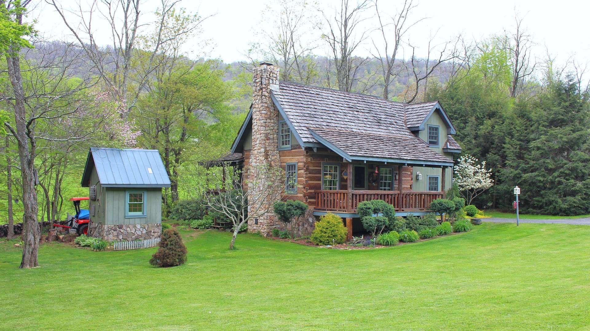 Offered at $279,900, this rustic 2-bedroom, 2-bath log cabin with wood floors, stone fireplace, many custom features, covered front and side porch, beautifully landscaped setting with fenced garden area, craftsman style outbuilding/workshop, another outbuilding and located in Chestnut Creek, just a short drive to West Jefferson, is perfect for your NC High Country retreat or full time home.